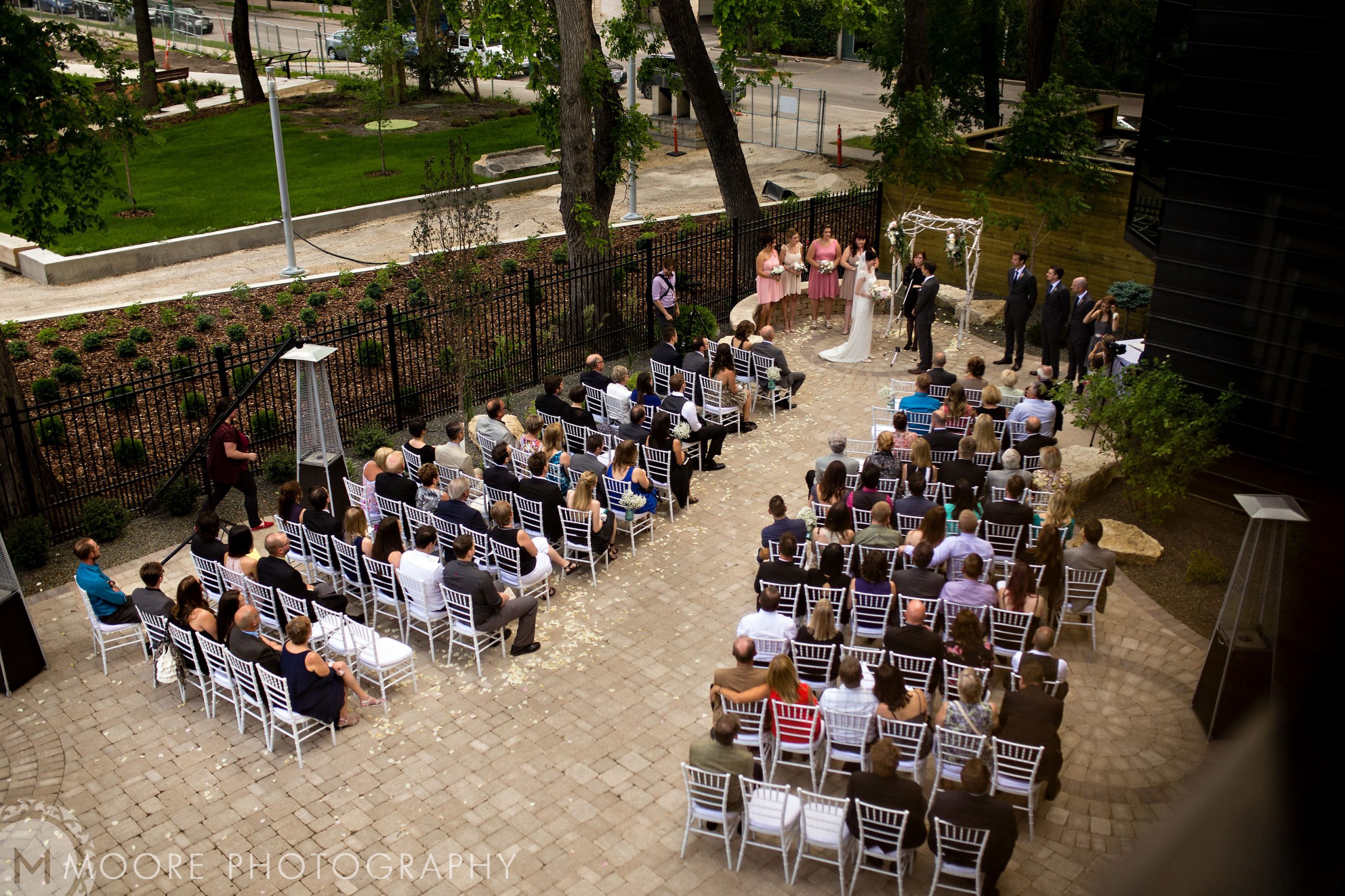 Winnipeg wedding venues set the scene for an outdoor ceremony with an arch and seated guests.