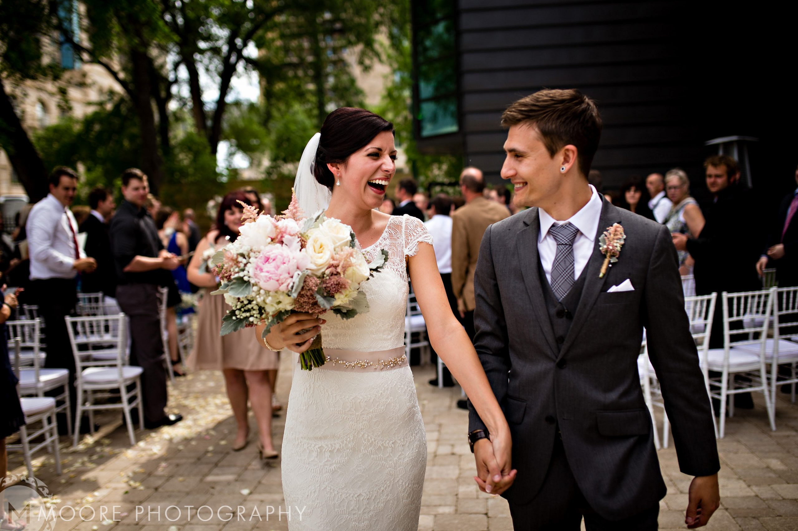 Bride and groom joyfully walk down the aisle in a lovely Winnipeg wedding venue.
