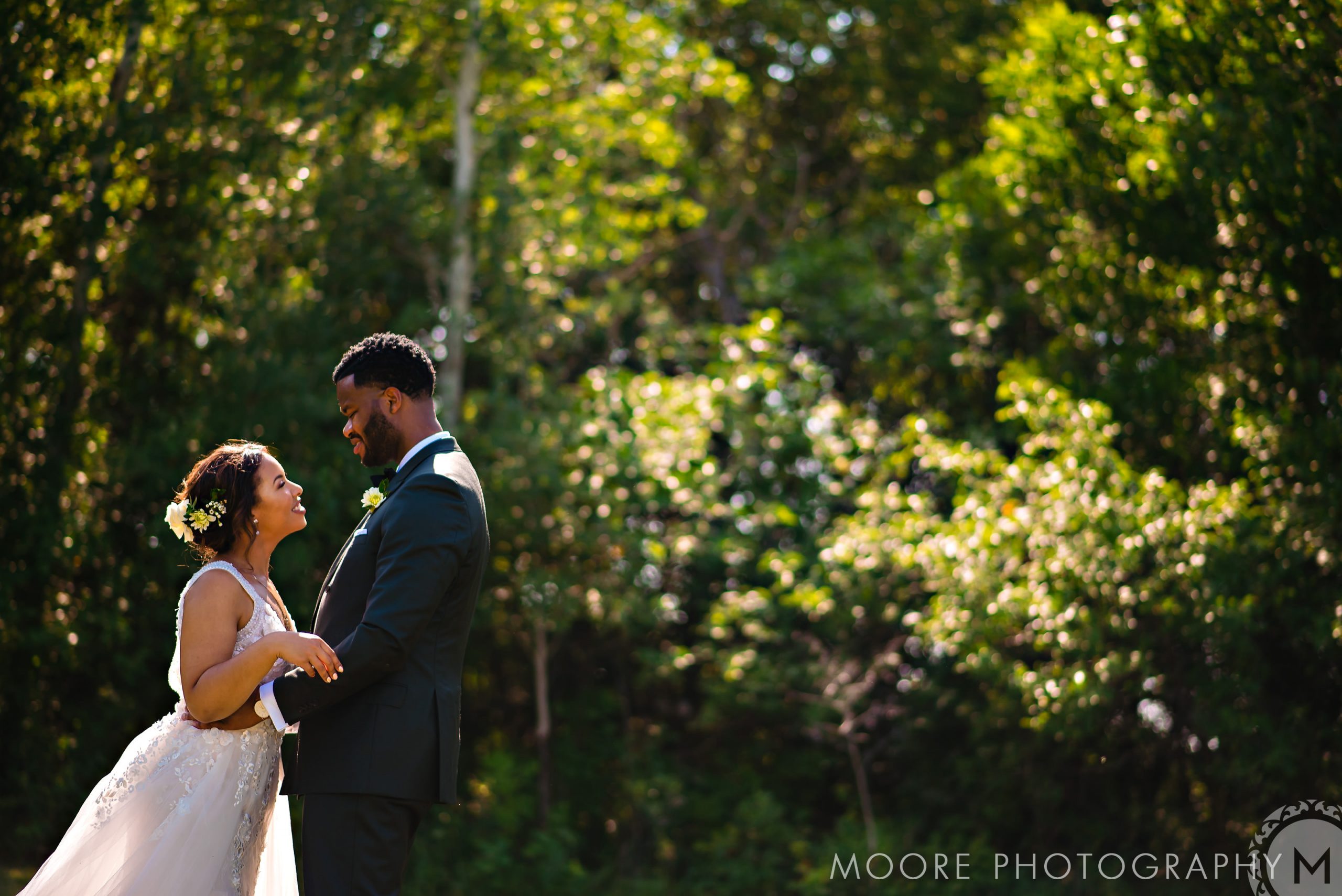 Bride and groom smiling at each other in a sunlit Winnipeg wedding venue.