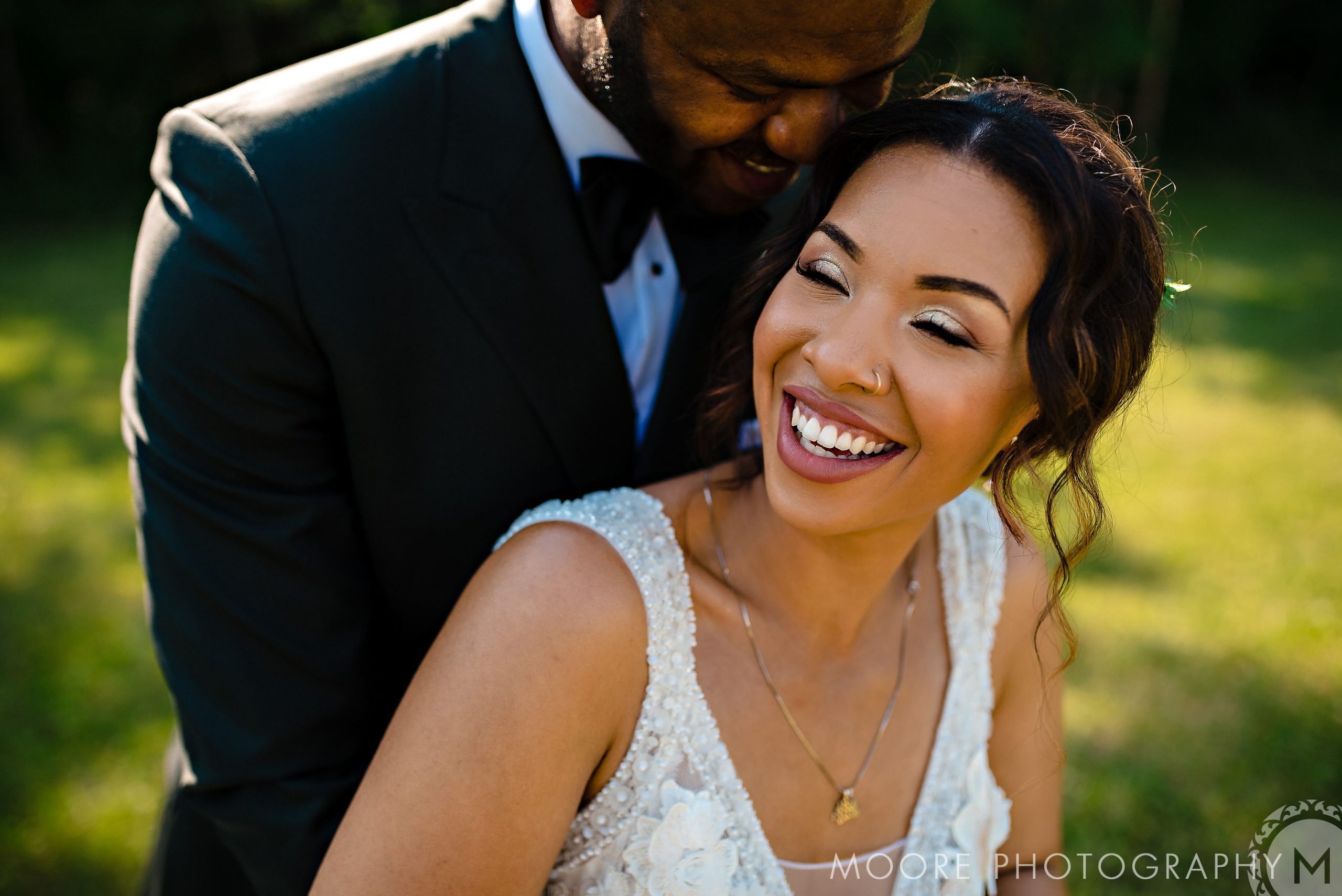 Bride and groom smiling joyfully in a sunlit Winnipeg wedding venue.