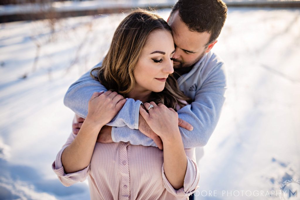 And engaged couple, embracing and posing for an engagement photo at the forks in Winnipeg