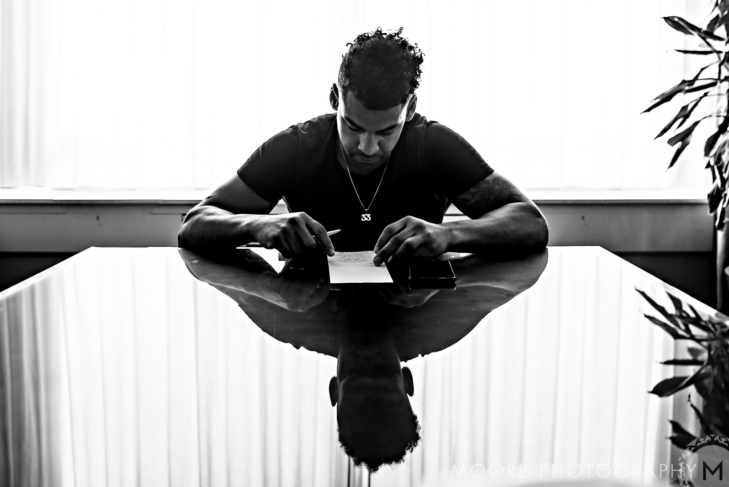 Andrew Harris reviews a wedding invite, its reflection clear on the glossy table surface.