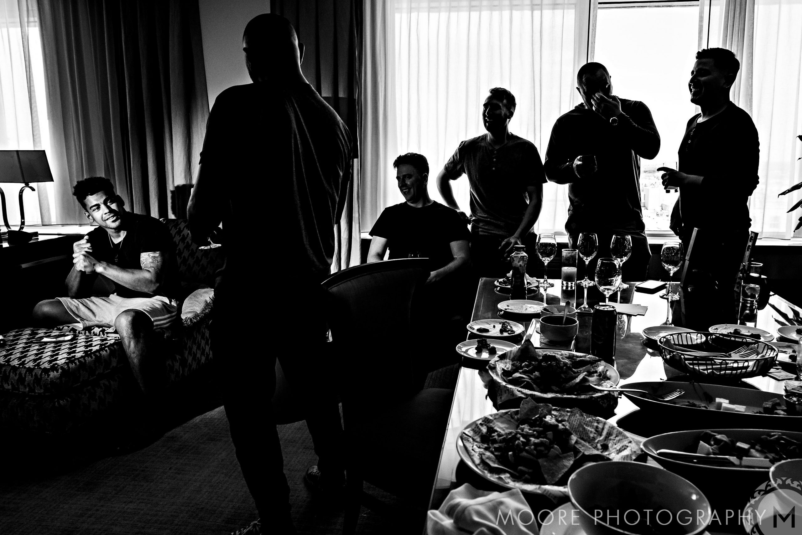 Andrew Harris's wedding guests laugh and chat, with snacks spread across the table.
