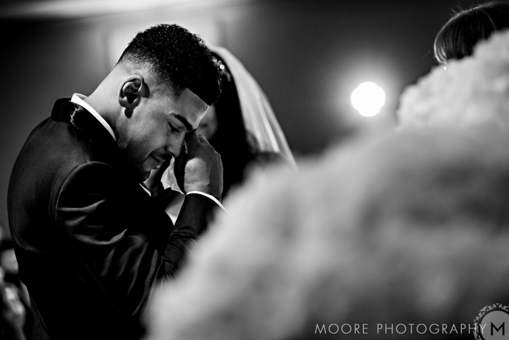 Andrew Harris wipes his tears during a black-and-white wedding ceremony.