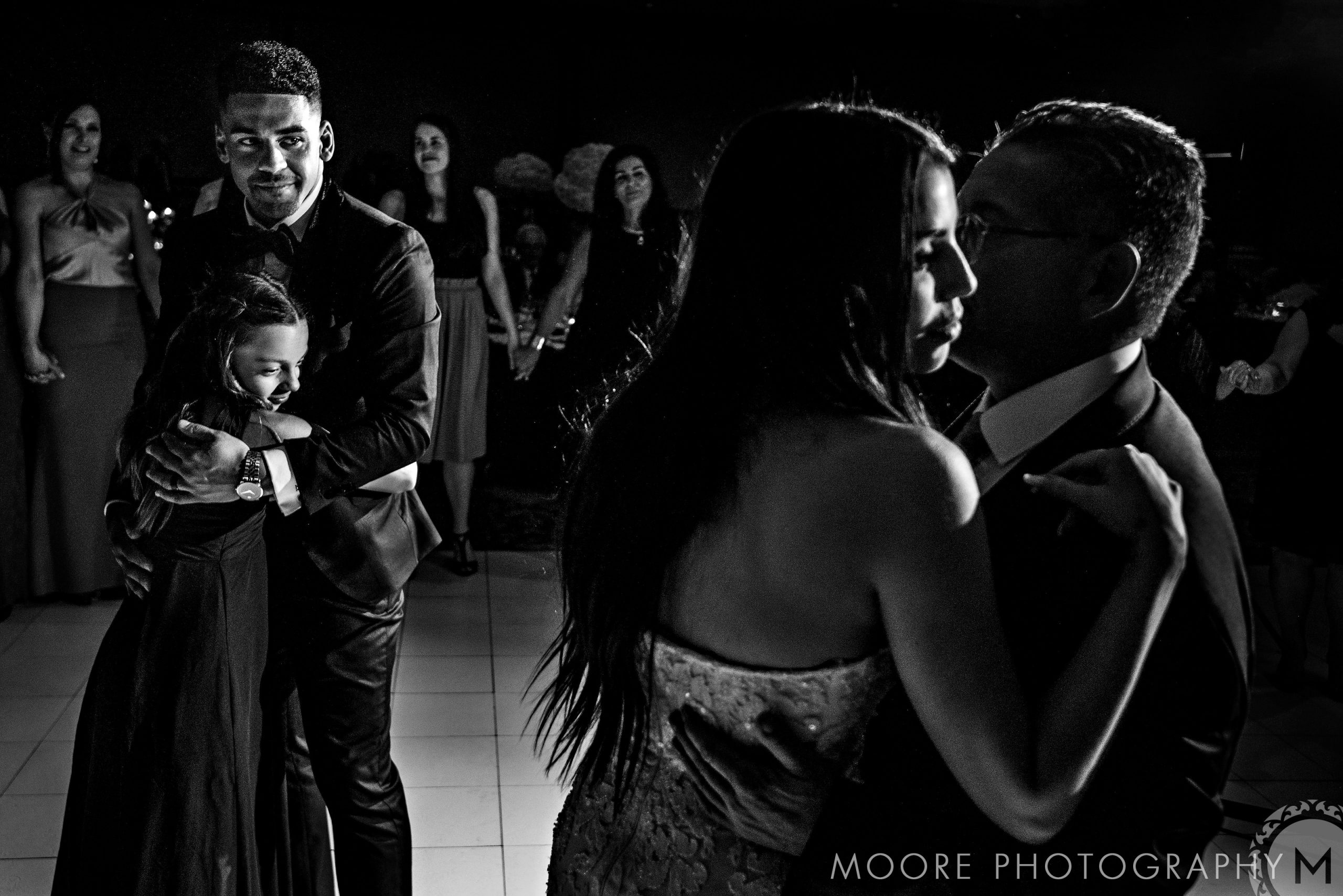 Couples dancing in formal attire at Andrew Harris' evening wedding; focus on two pairs.