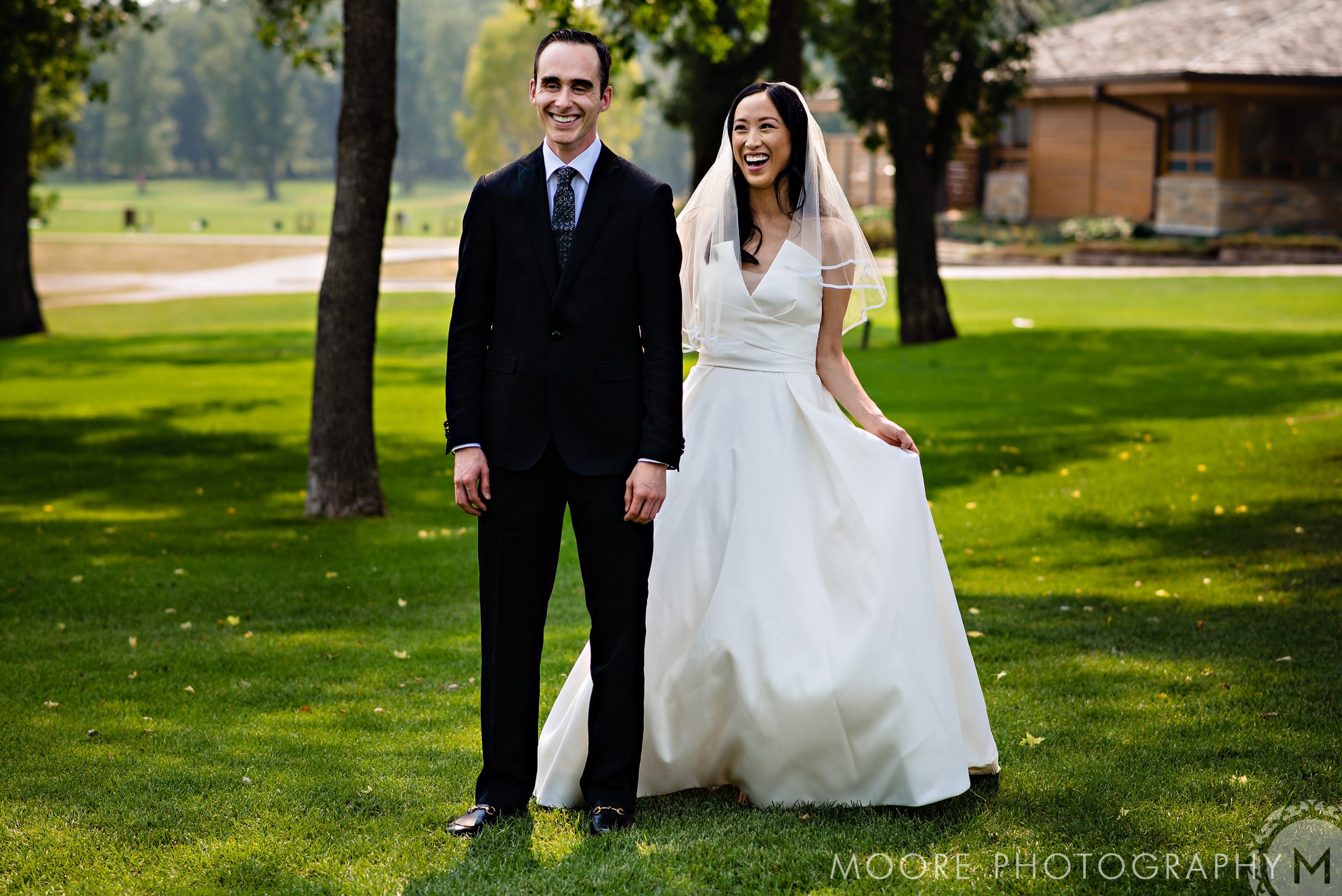 Bride and groom smiling at a sunny Winnipeg wedding venue.