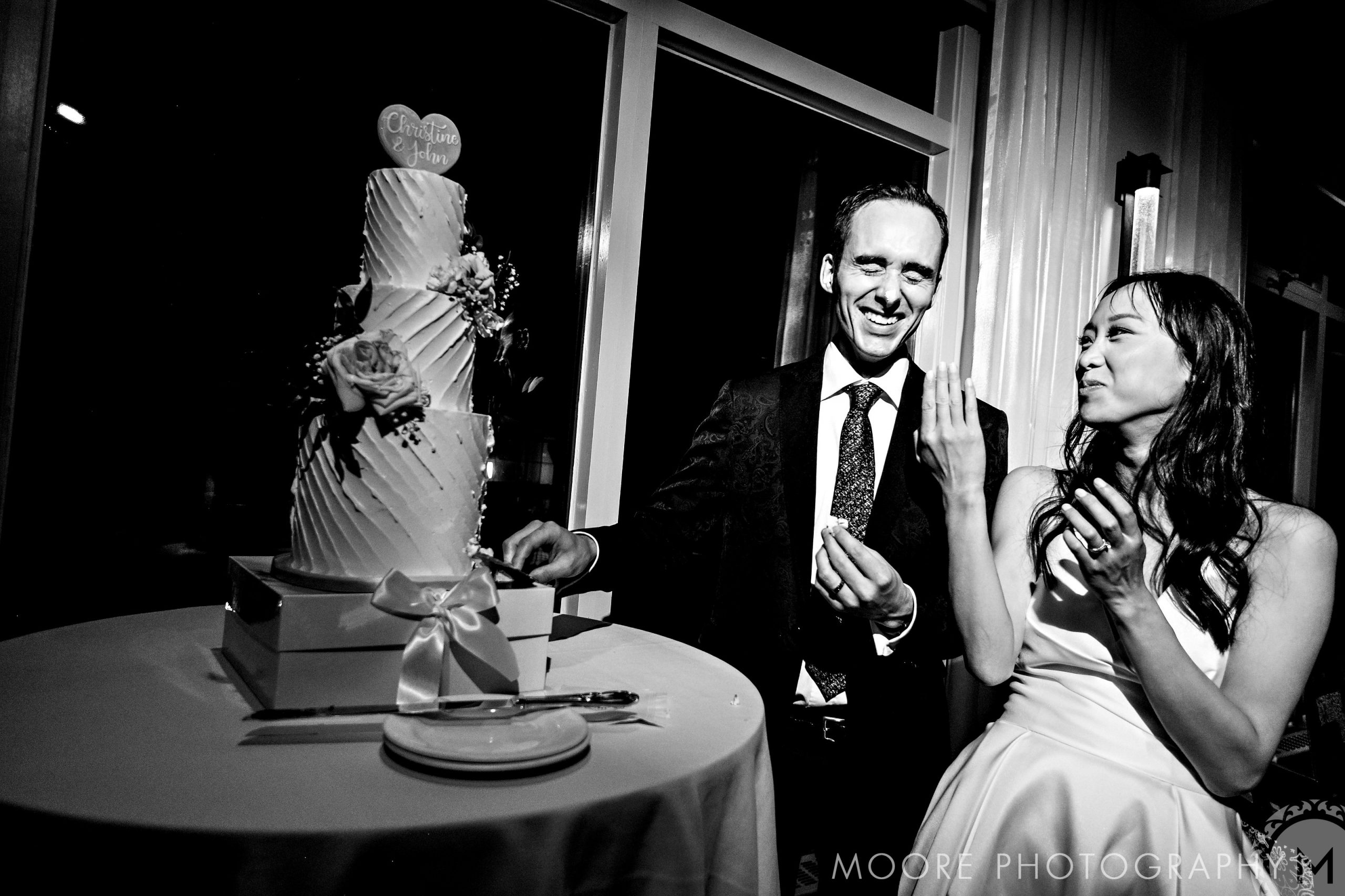 The bride and groom delight in cake-cutting at a top Winnipeg wedding venue.