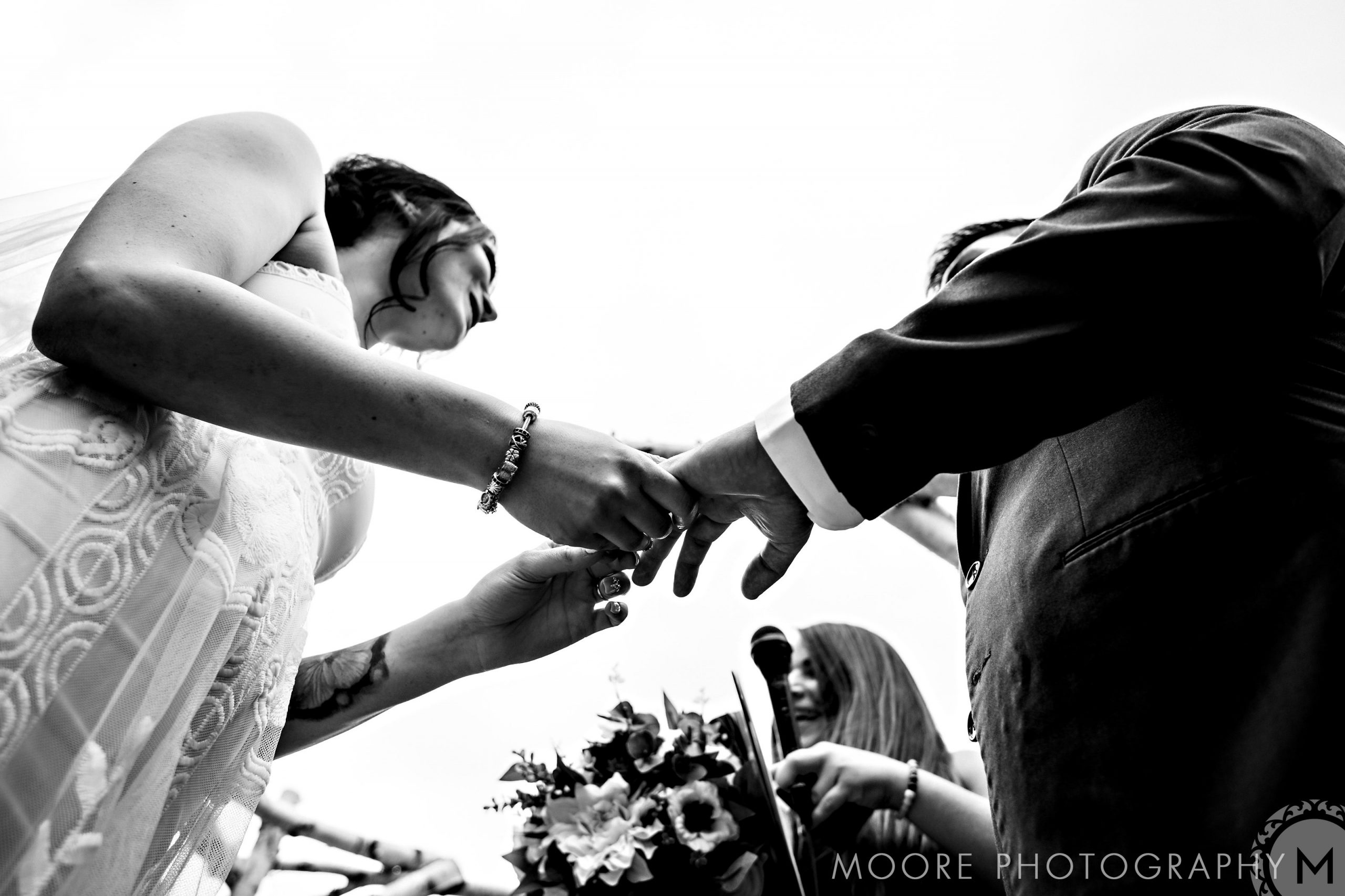 Bride and groom hold hands at Winnipeg wedding, viewed from below, in black and white.