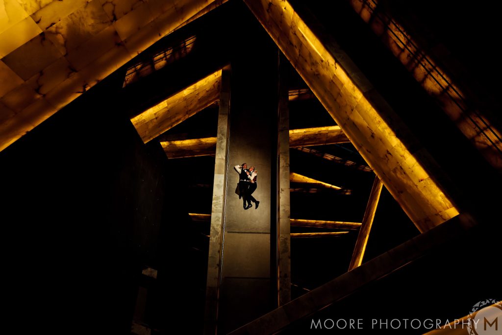Couple embraces on a dimly lit walkway, reminiscent of Winnipeg wedding venues.