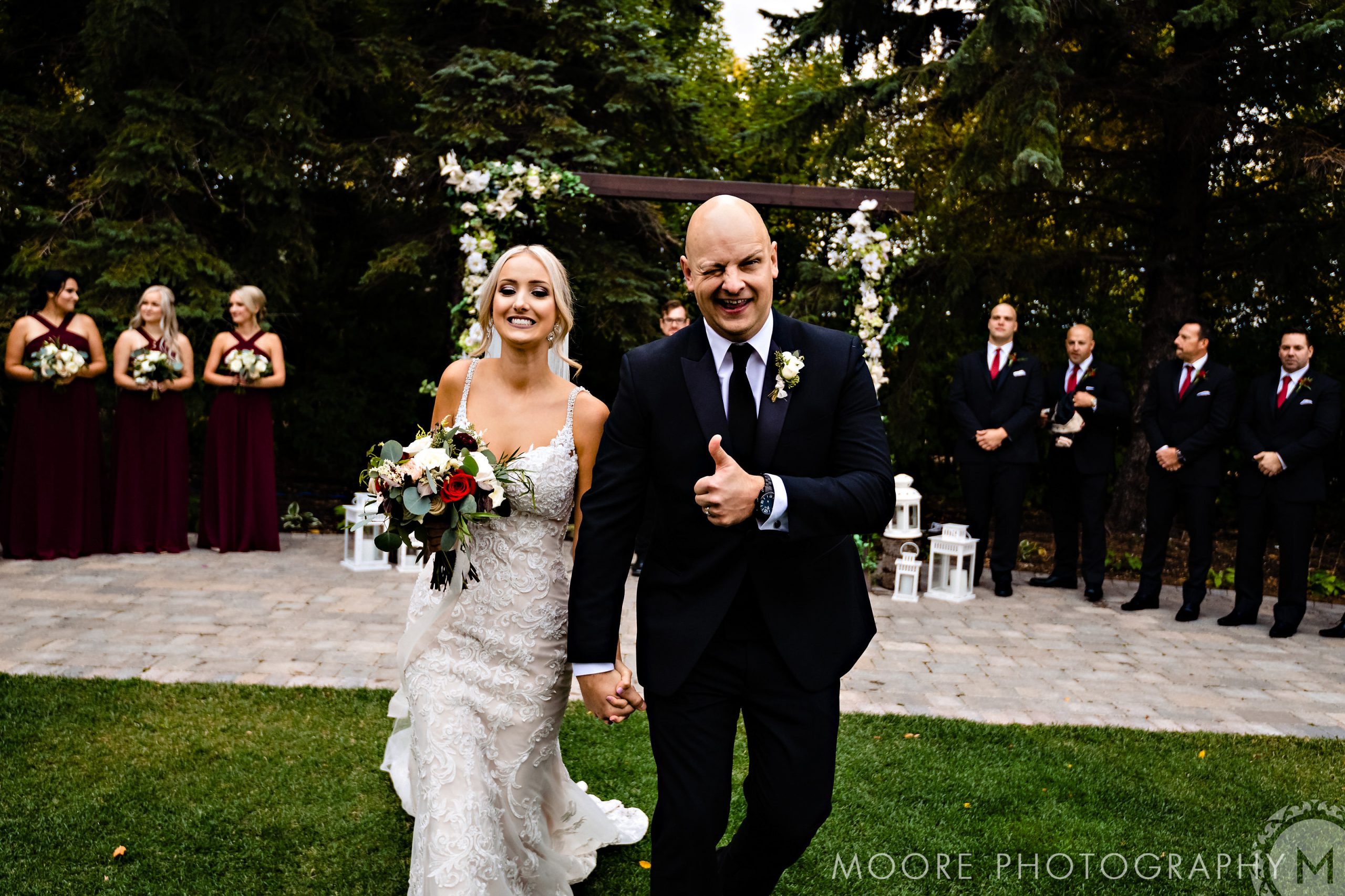 Bride and groom smile, walk down the aisle at a stunning Winnipeg wedding venue.