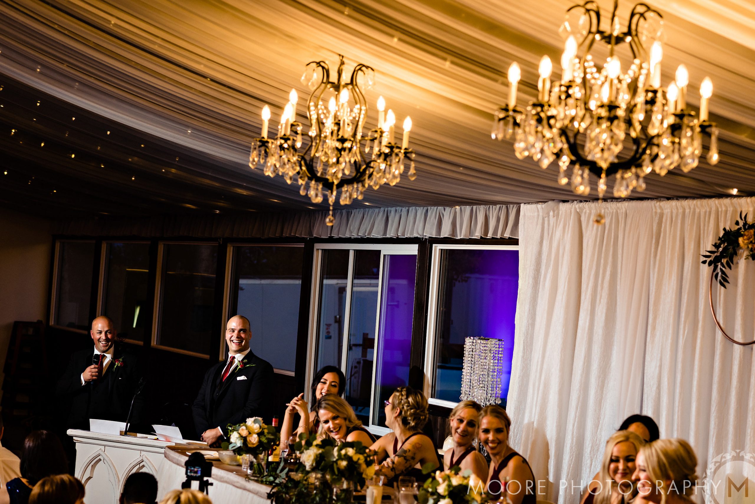 Guests at a Winnipeg wedding venue enjoy chandeliers and a beautifully decorated table.