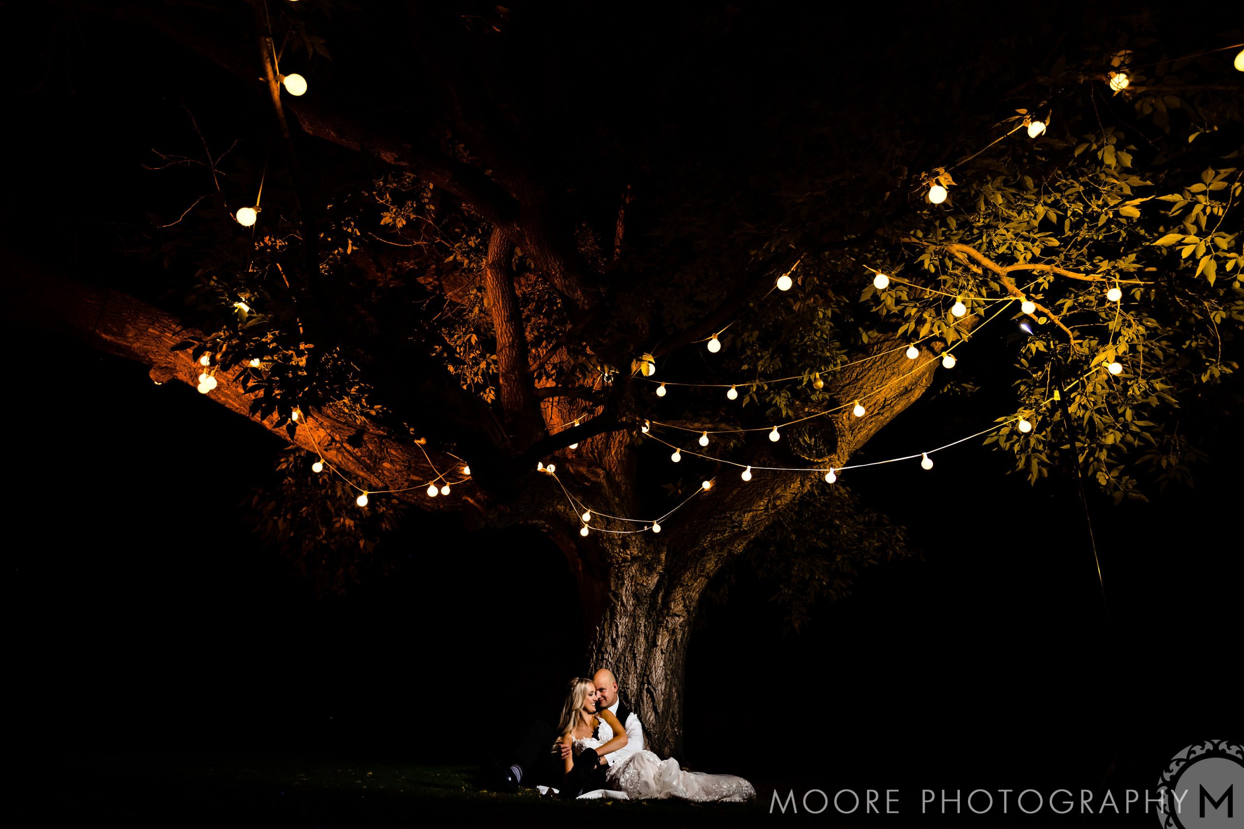 Couple embraces under string lights at night, a perfect Winnipeg wedding venue scene.