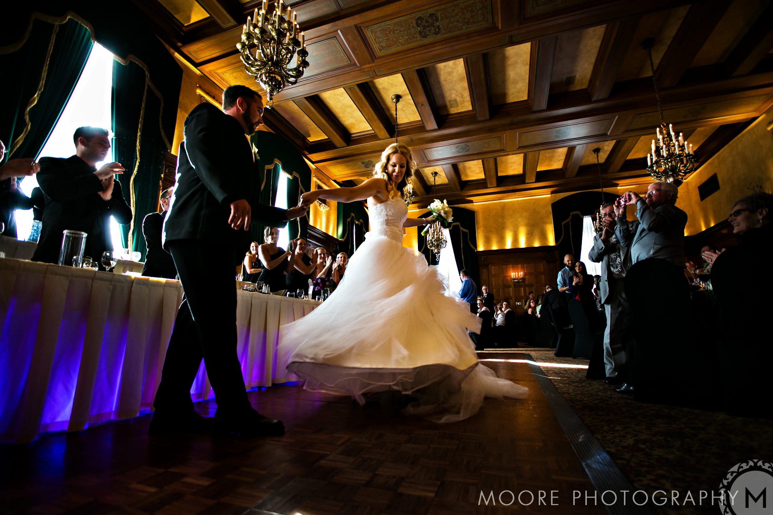 Bride and groom dancing under chandeliers at a top Winnipeg wedding venue.