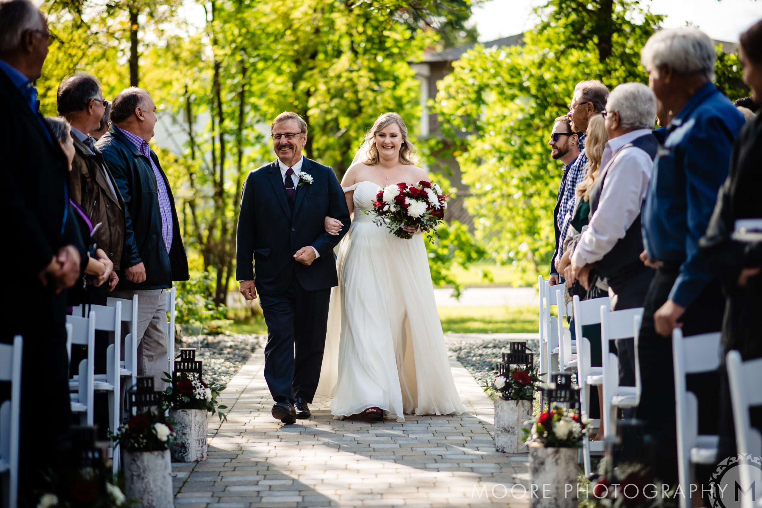 Bride walking down the aisle at a picturesque Winnipeg wedding venue, surrounded by guests.