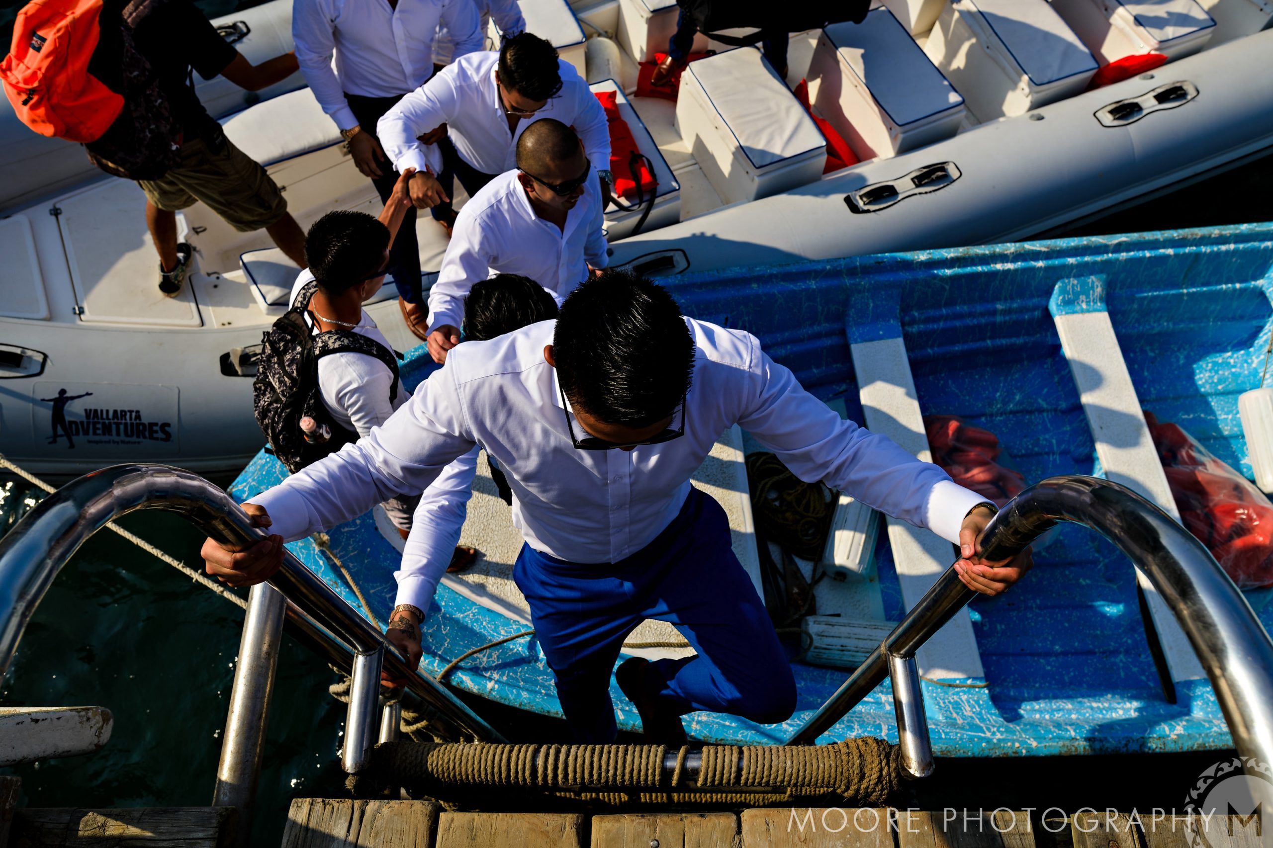 Guests in formal attire board a boat for a Puerto Vallarta destination wedding.