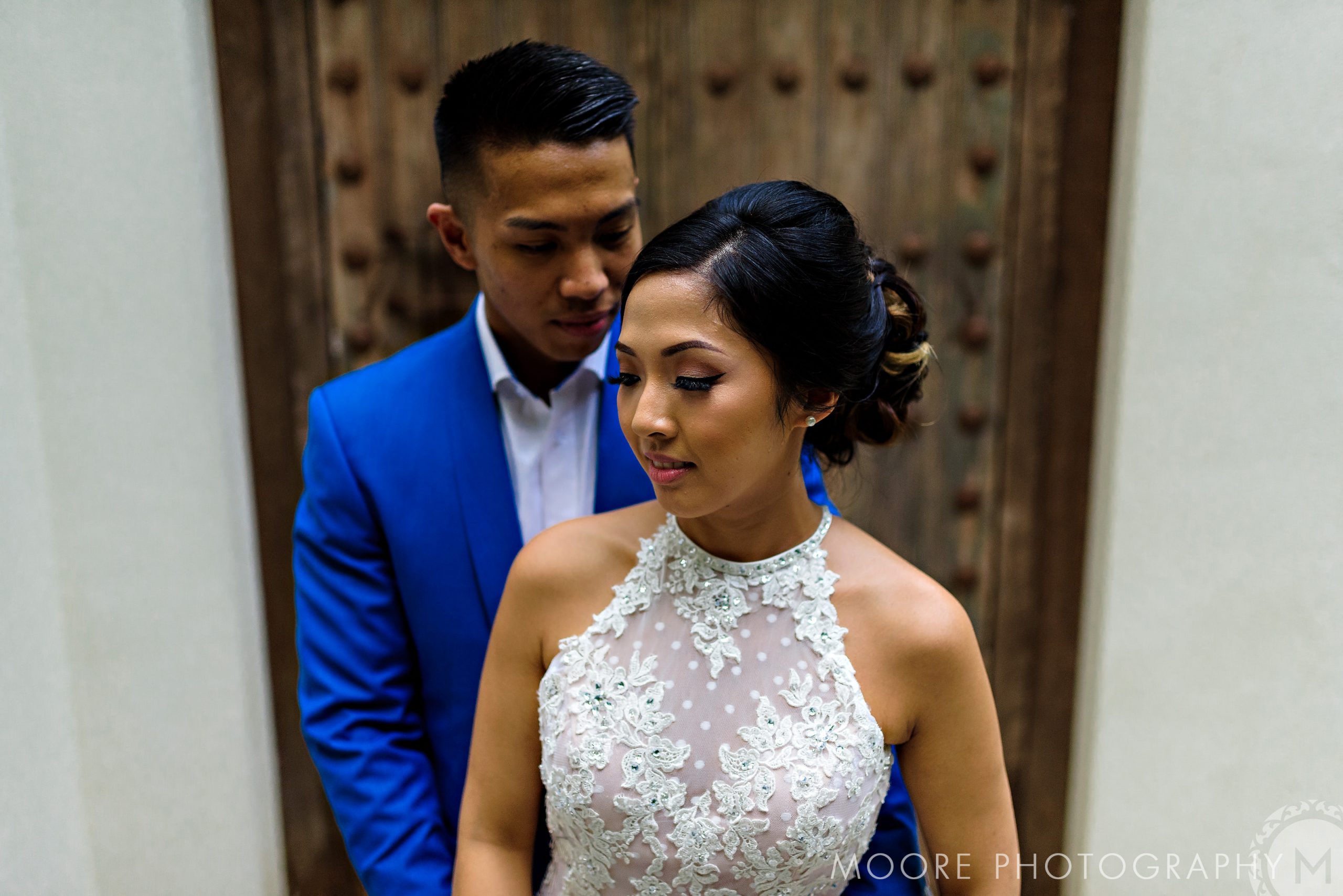A couple in formal attire, the man embracing the woman on a Puerto Vallarta beach.