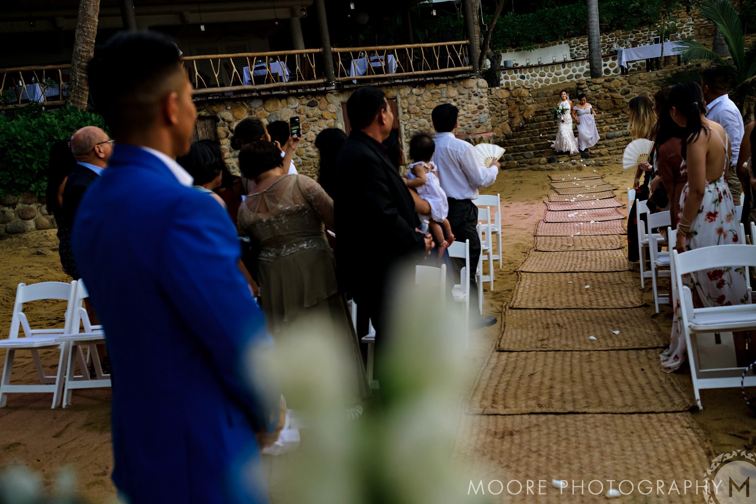 Puerto Vallarta destination wedding, flower girls lead the way; guests enjoy the outdoor ceremony.