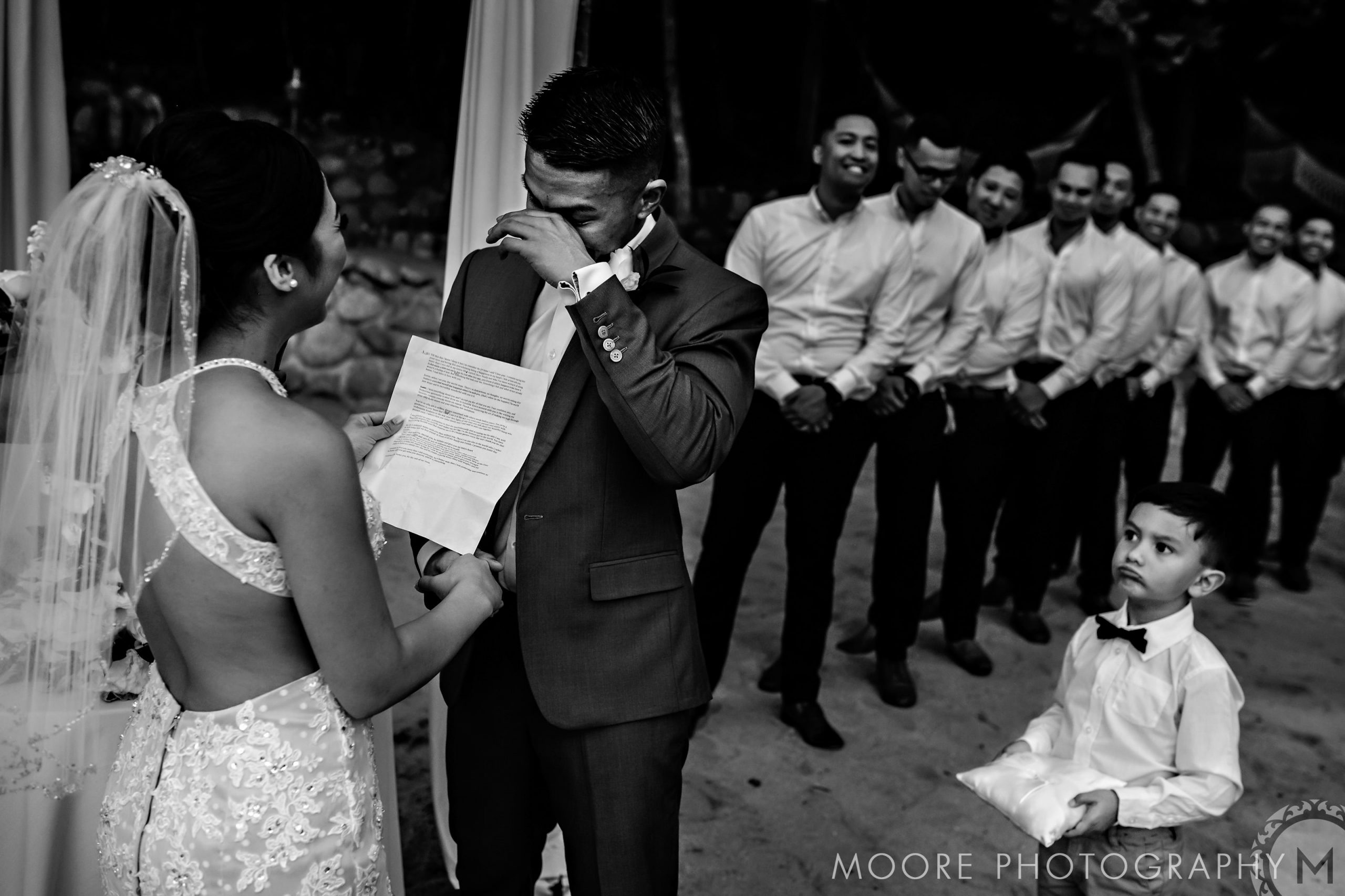 Groom cries during vows, bride smiles; a picturesque Puerto Vallarta destination wedding.