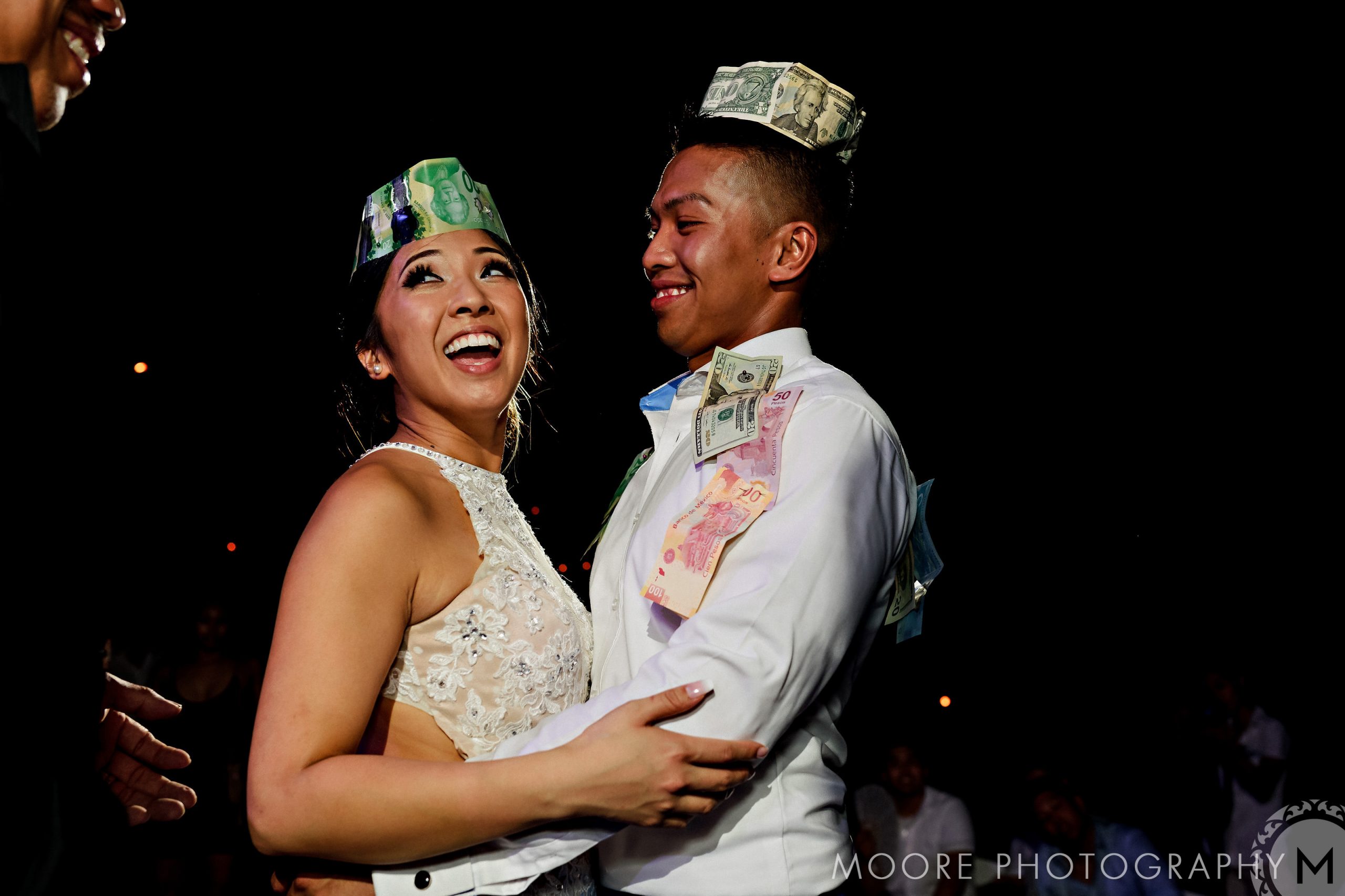 Couple smiling and dancing, in money-themed attire at a Puerto Vallarta destination wedding.