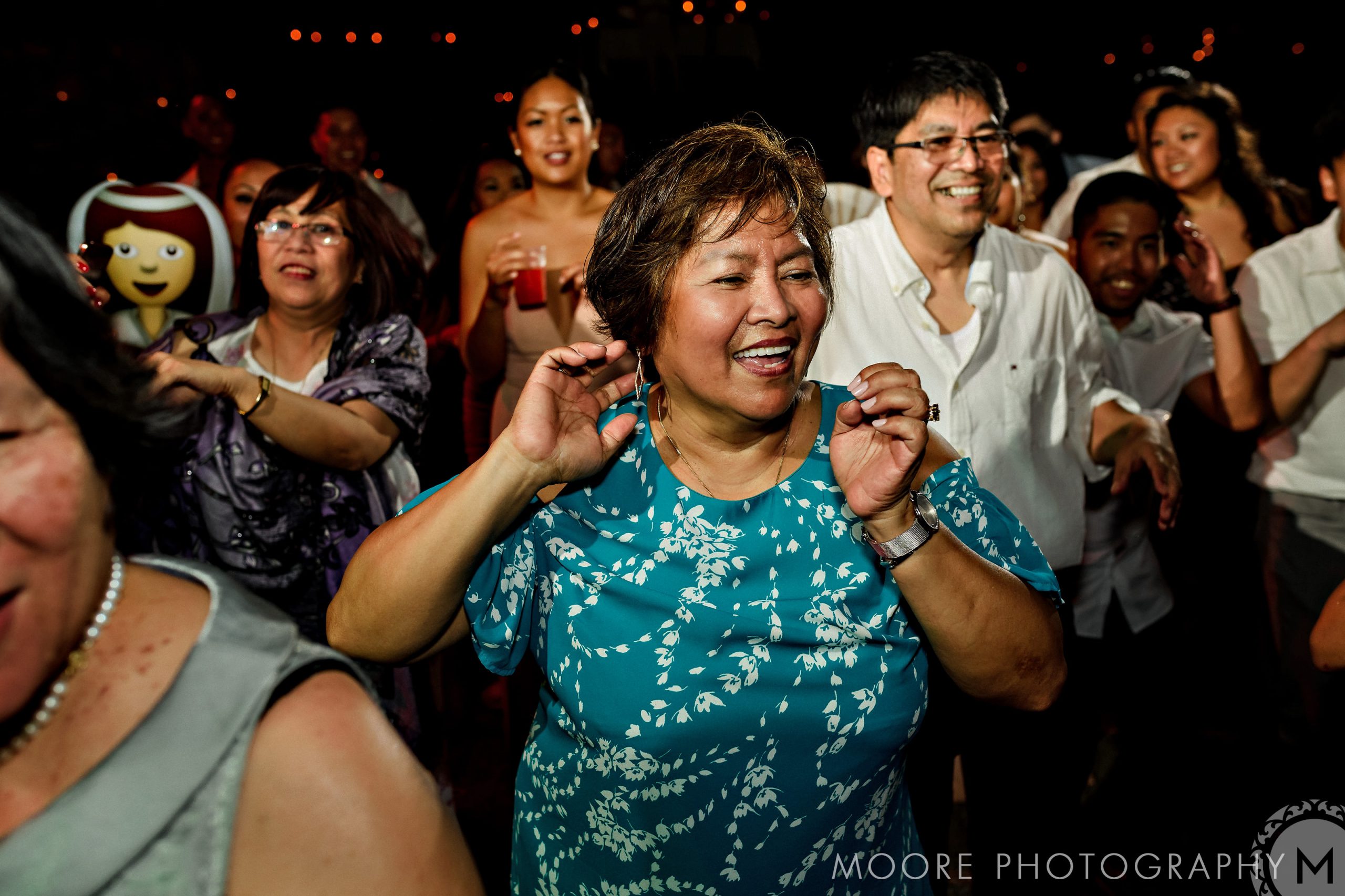 People joyfully dancing at a Puerto Vallarta destination wedding in festive attire.