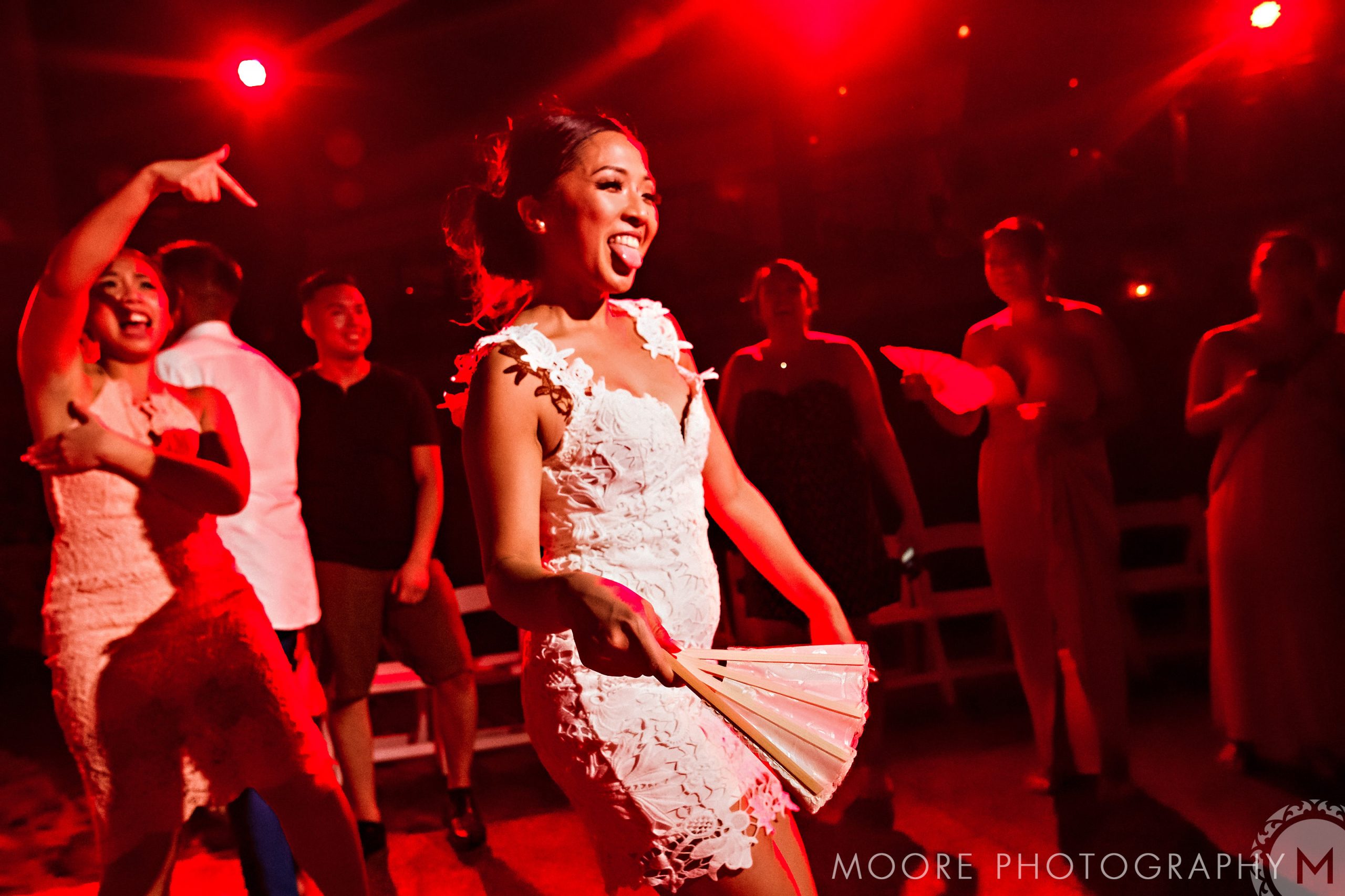 Woman in white dress dances with a fan at a Puerto Vallarta destination wedding.
