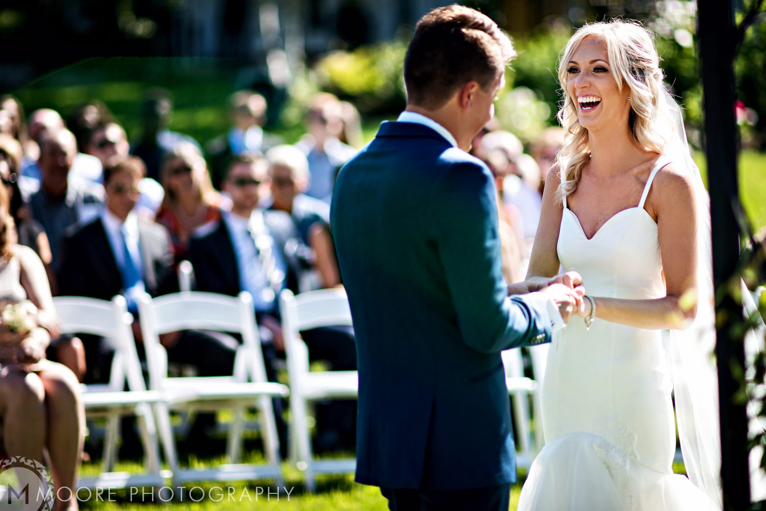 The wedding celebration sees a bride and groom exchange vows outdoors with seated guests.