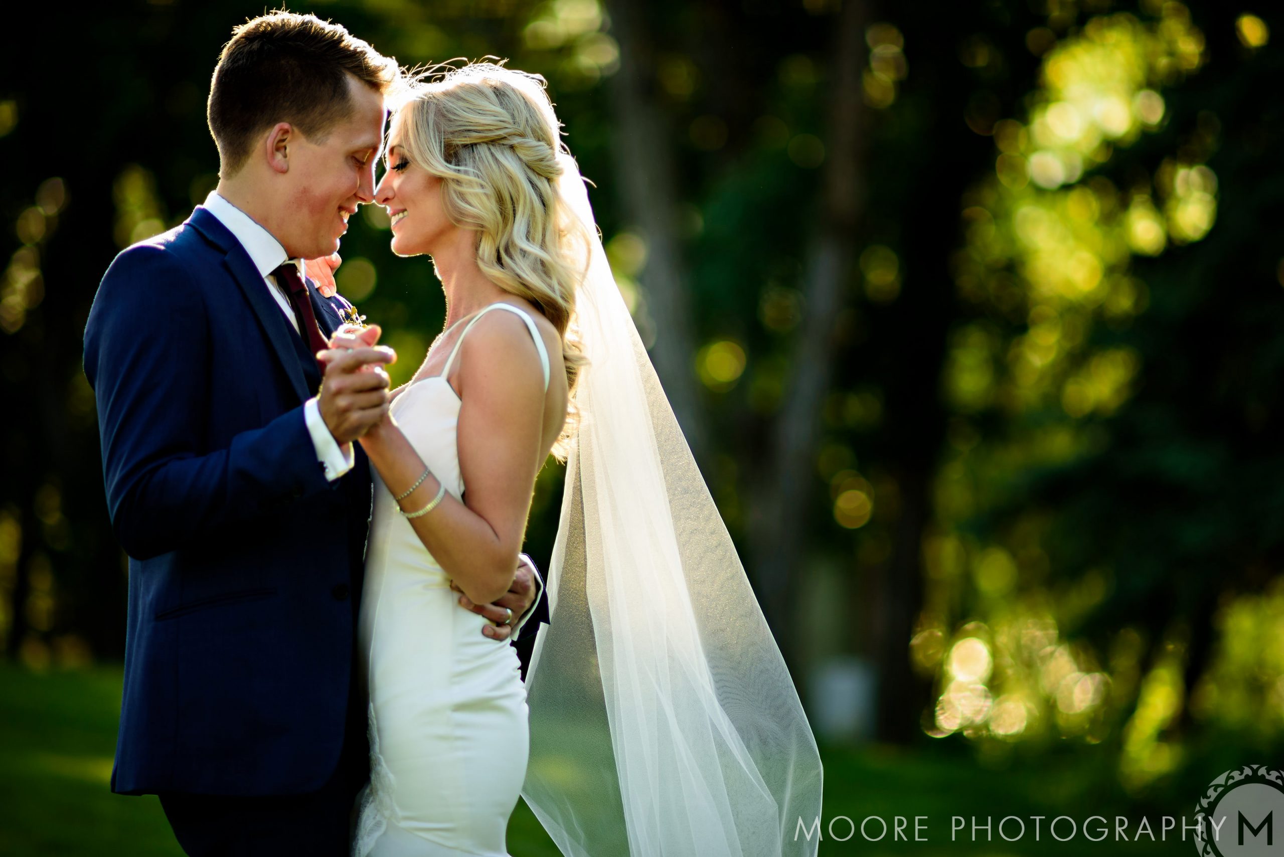 Bride and groom dancing outdoors at a scenic Winnipeg wedding venue.
