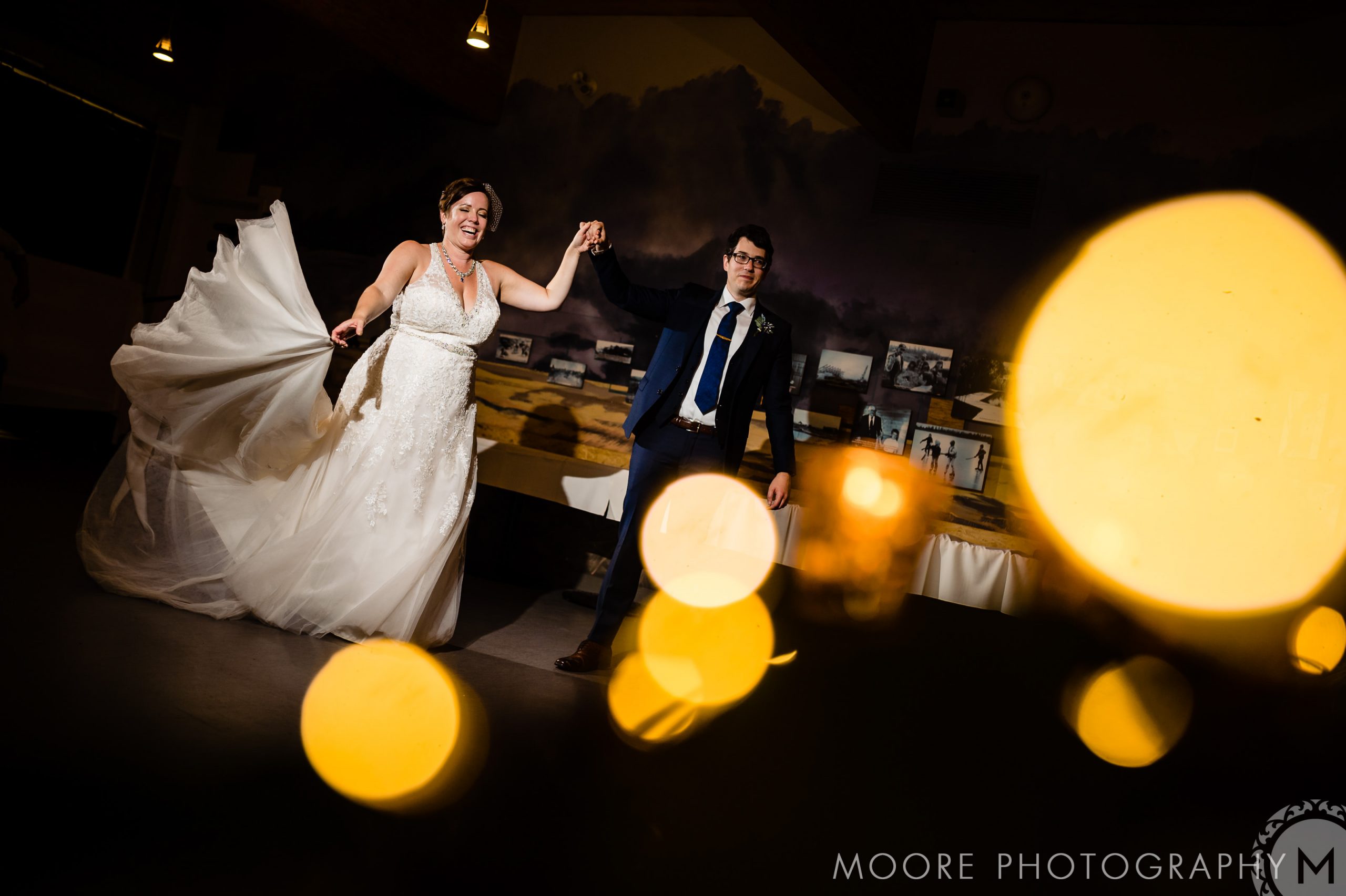 Bride and groom dancing at Winnipeg venues, amid warm lights and a dark backdrop.