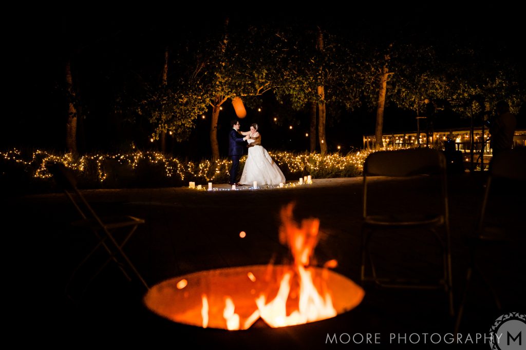 A bride and groom dancing at night with a fire in the foreground in Winnipeg Manitoba