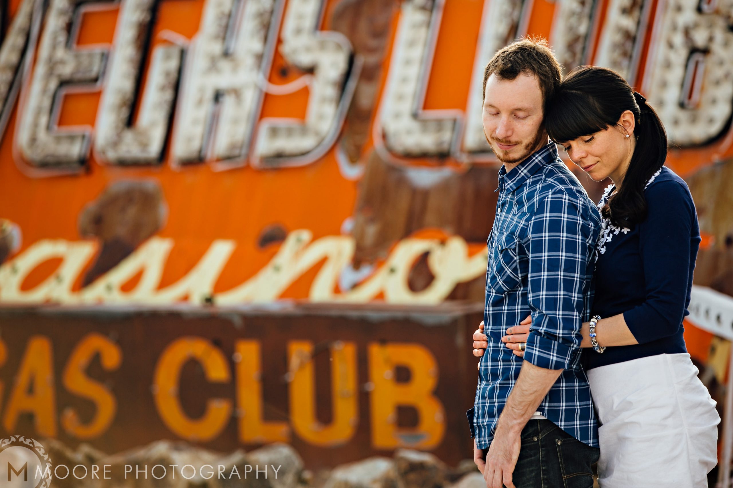 A couple embracing before a vintage casino sign, perfect for destination wedding photography.
