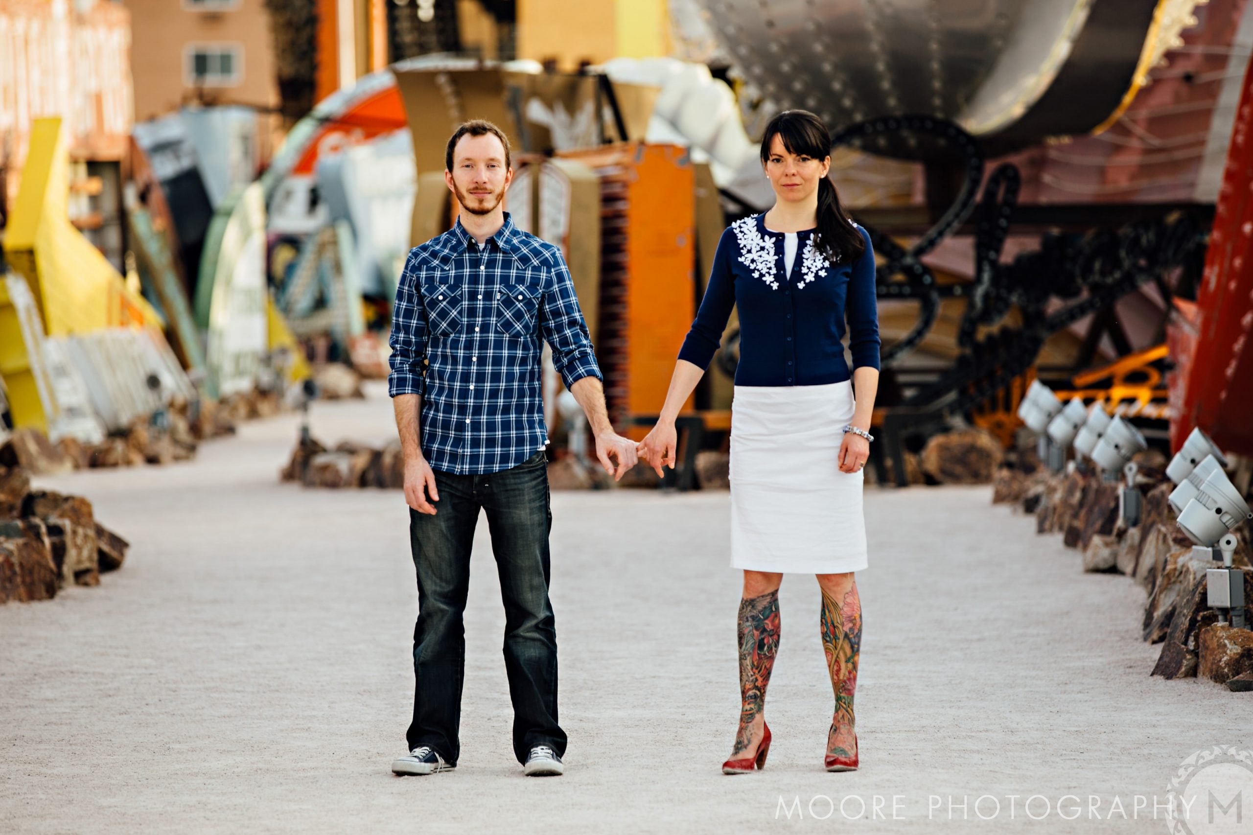 Couple holding hands in an outdoor, destination wedding photography with colorful sculptures.