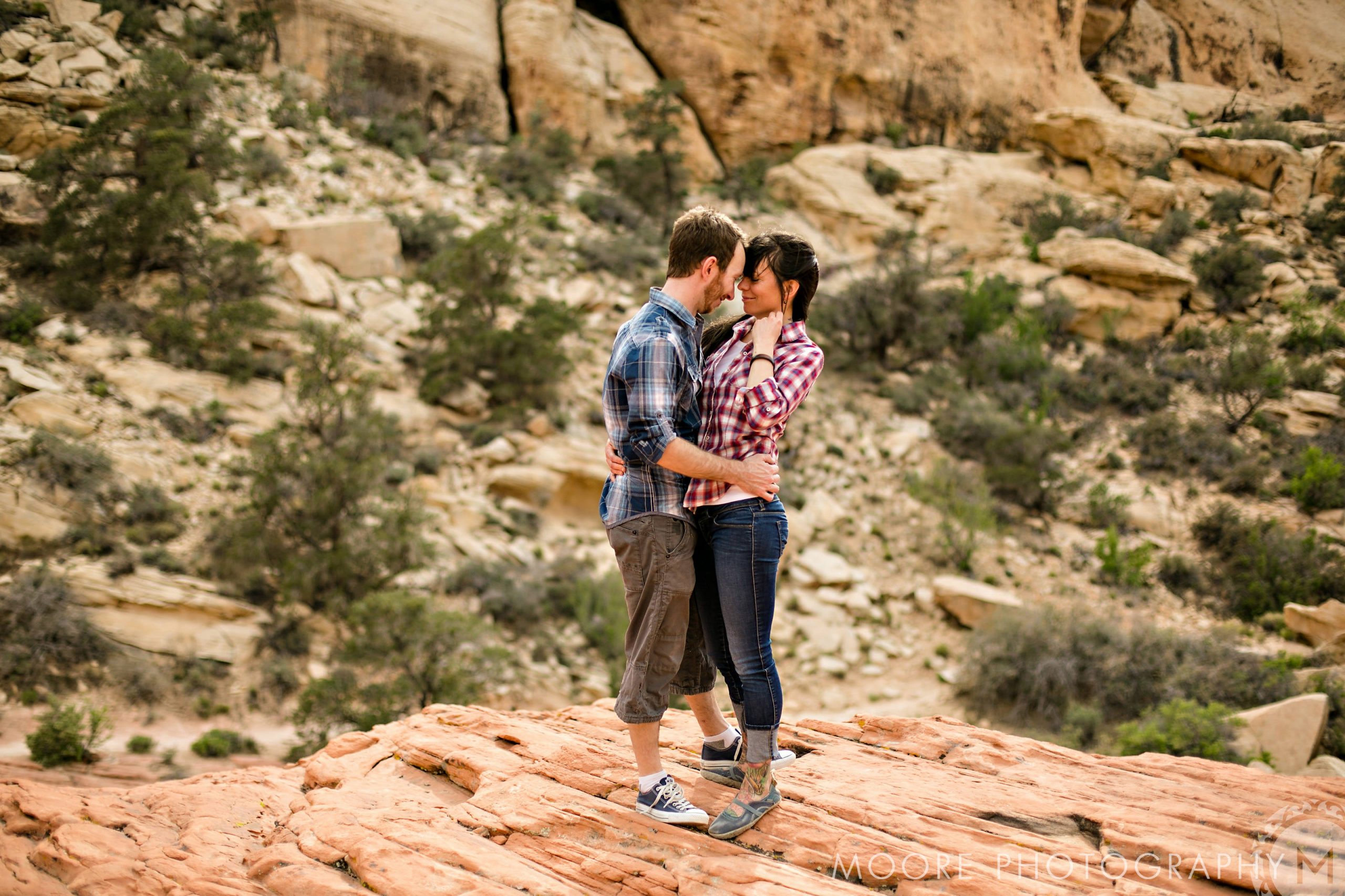 Couple hugging on rocky terrain, a perfect shot for destination wedding photography.