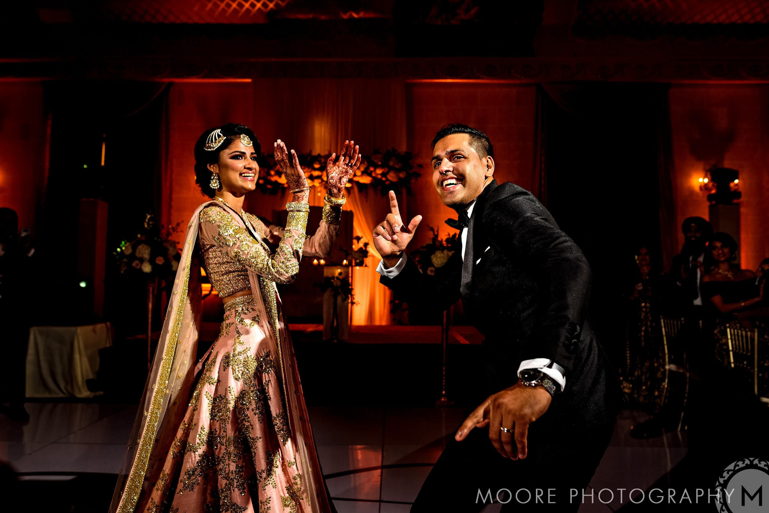 A couple dances joyfully at a wedding reception in Winnipeg's warm lighting.