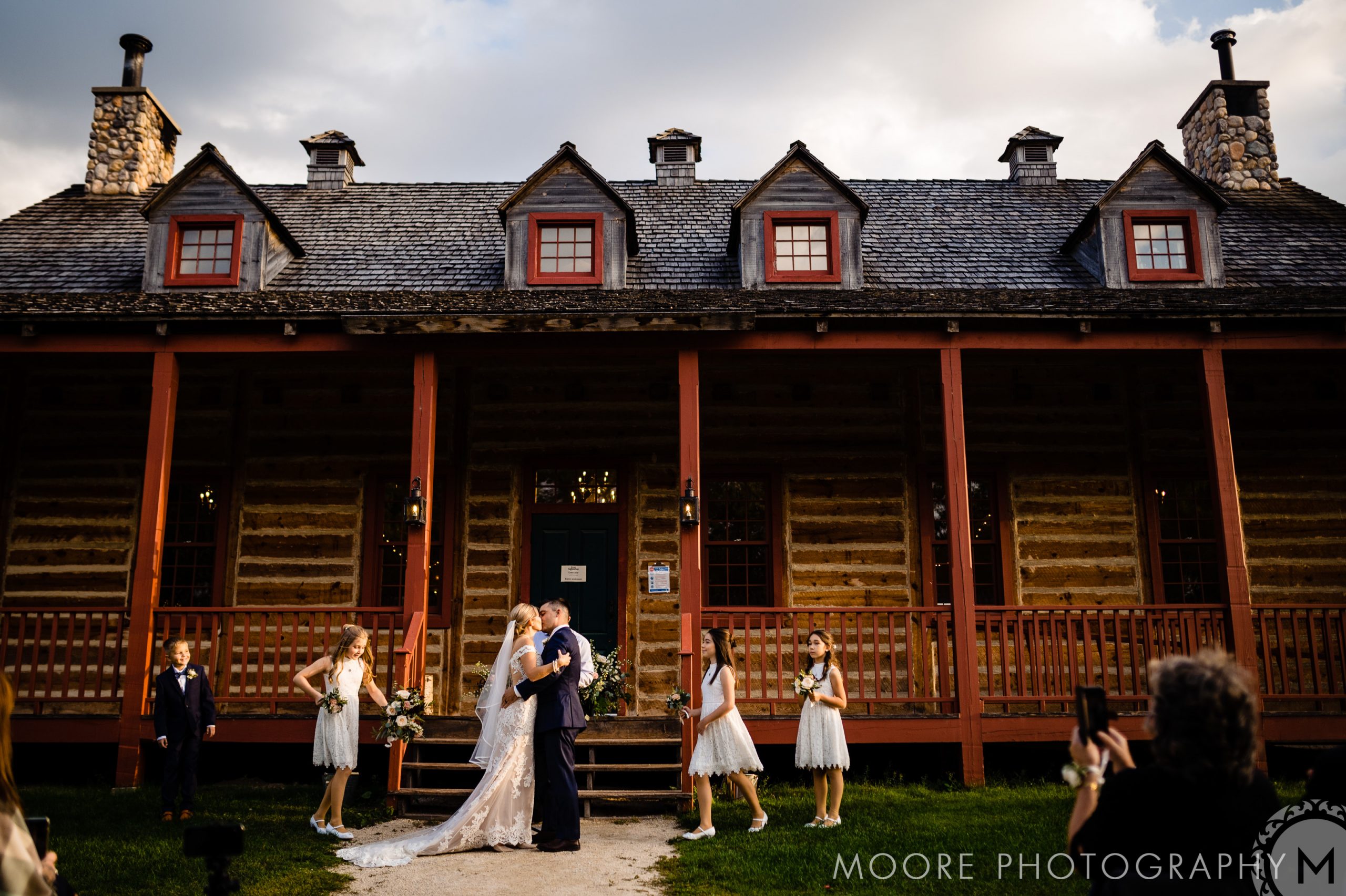 Bride and groom kiss at a rustic building, one of the charming Winnipeg wedding venues.