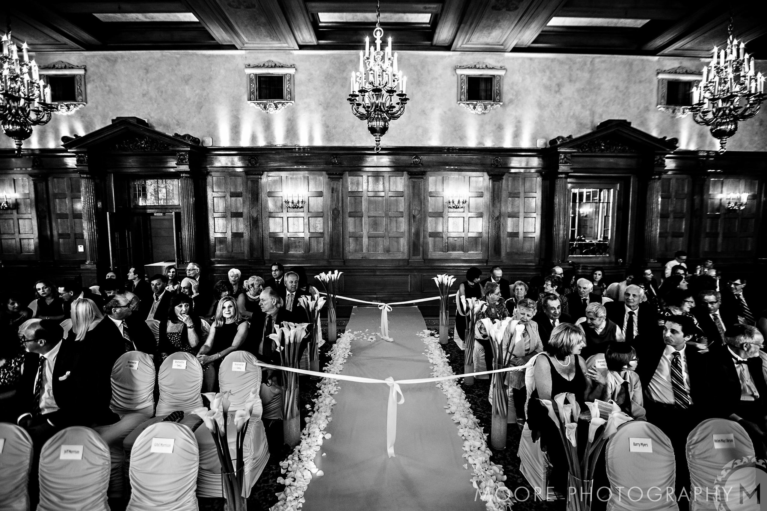 Elegant indoor wedding ceremony at top Winnipeg venues, with floral aisles and chandeliers.
