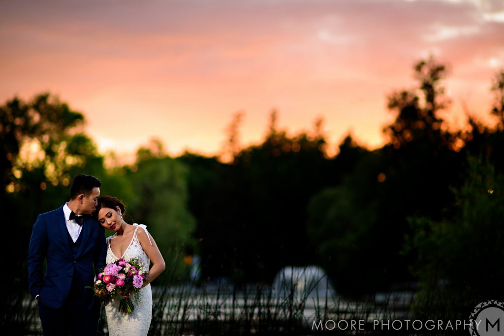 Bride and groom, embracing at Sunset for a wedding photo with nature in the background at Assiniboine Park