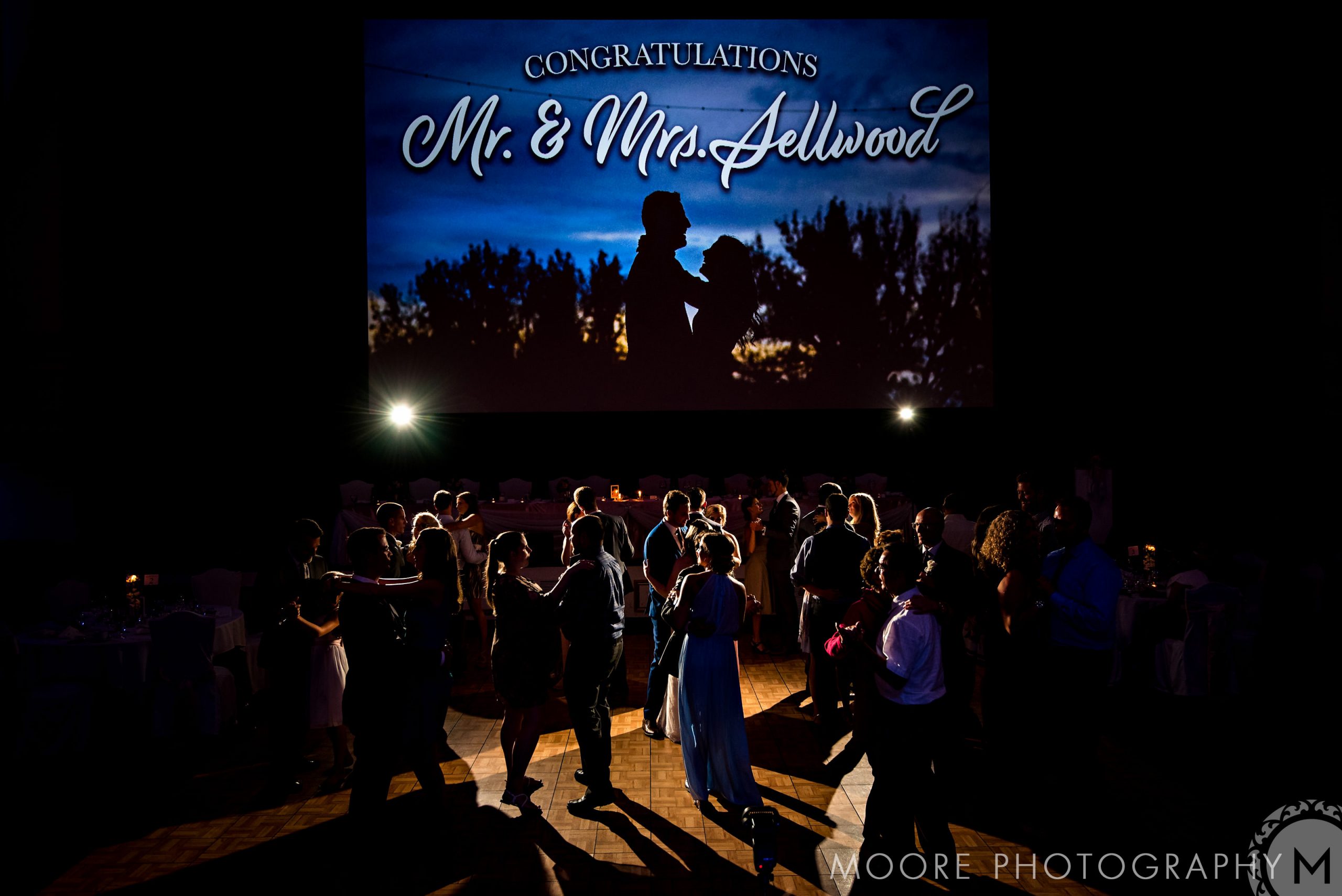Guests dancing at a Winnipeg wedding venue under a "Congratulations Mr. & Mrs." sign.