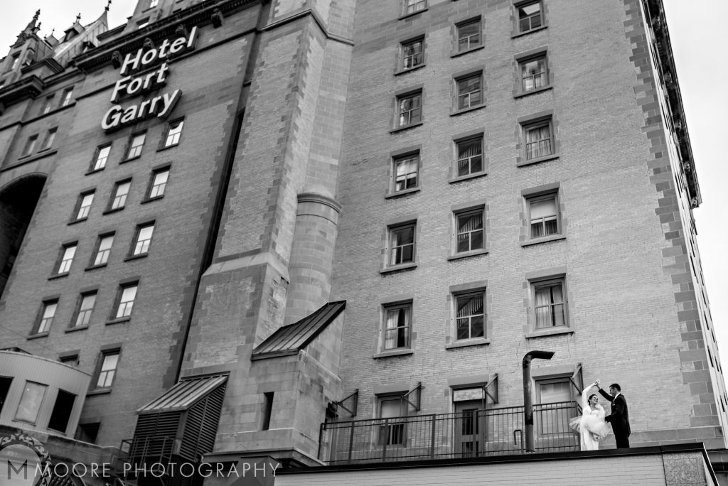 A bride and groom dancing next to the Fort Garry Hotel in Winnipeg