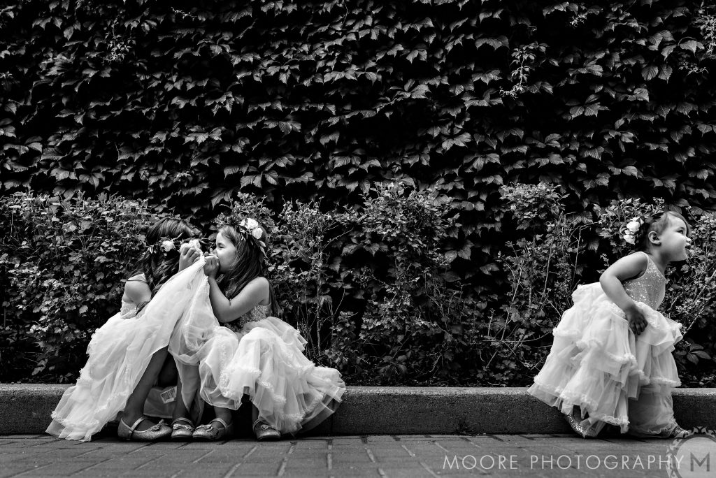 Young flower girls whispering and having fun in a black-and-white photo