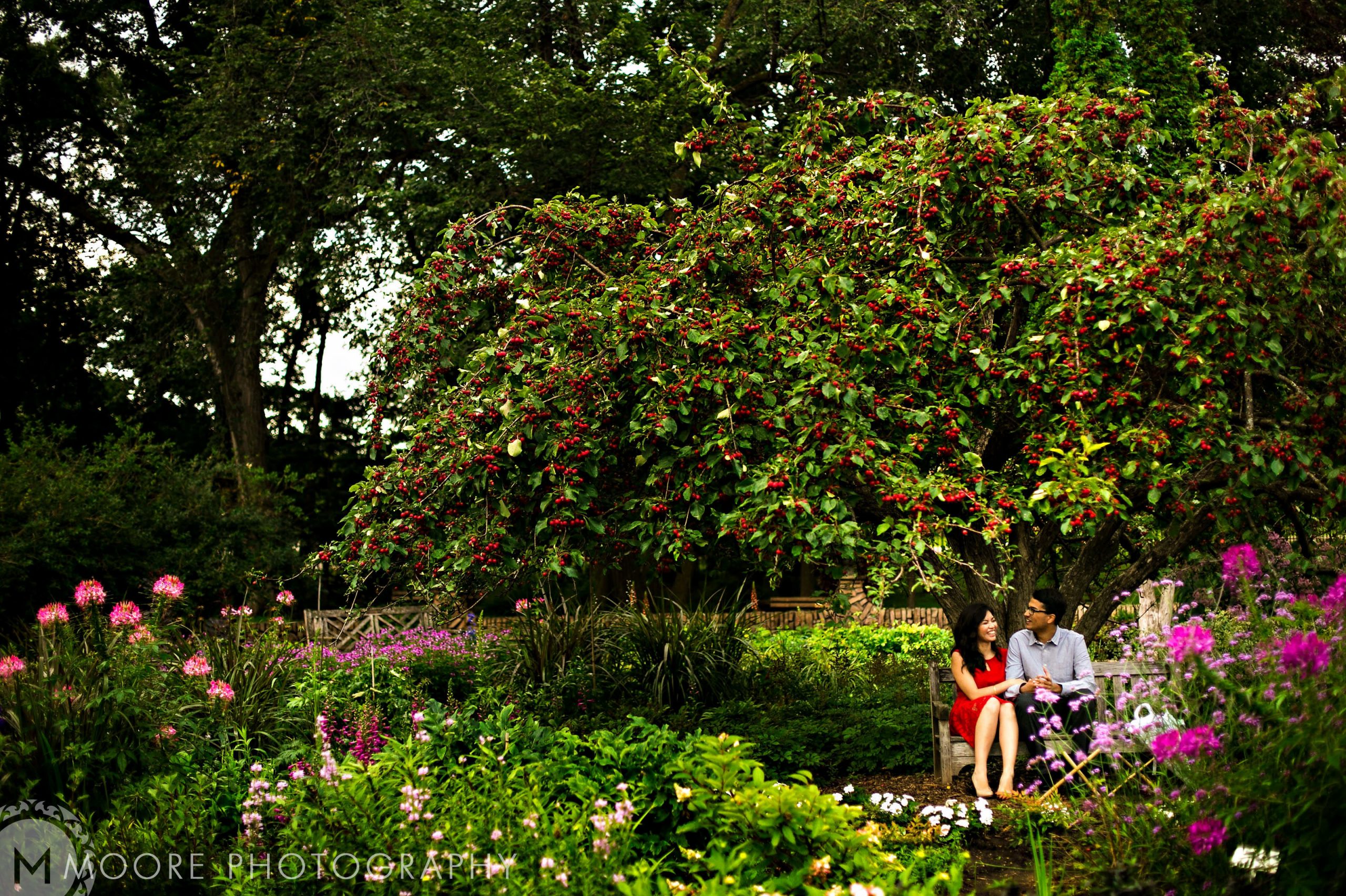 Couple enjoying a relaxed moment on a bench amidst vibrant garden flowers in Winnipeg.