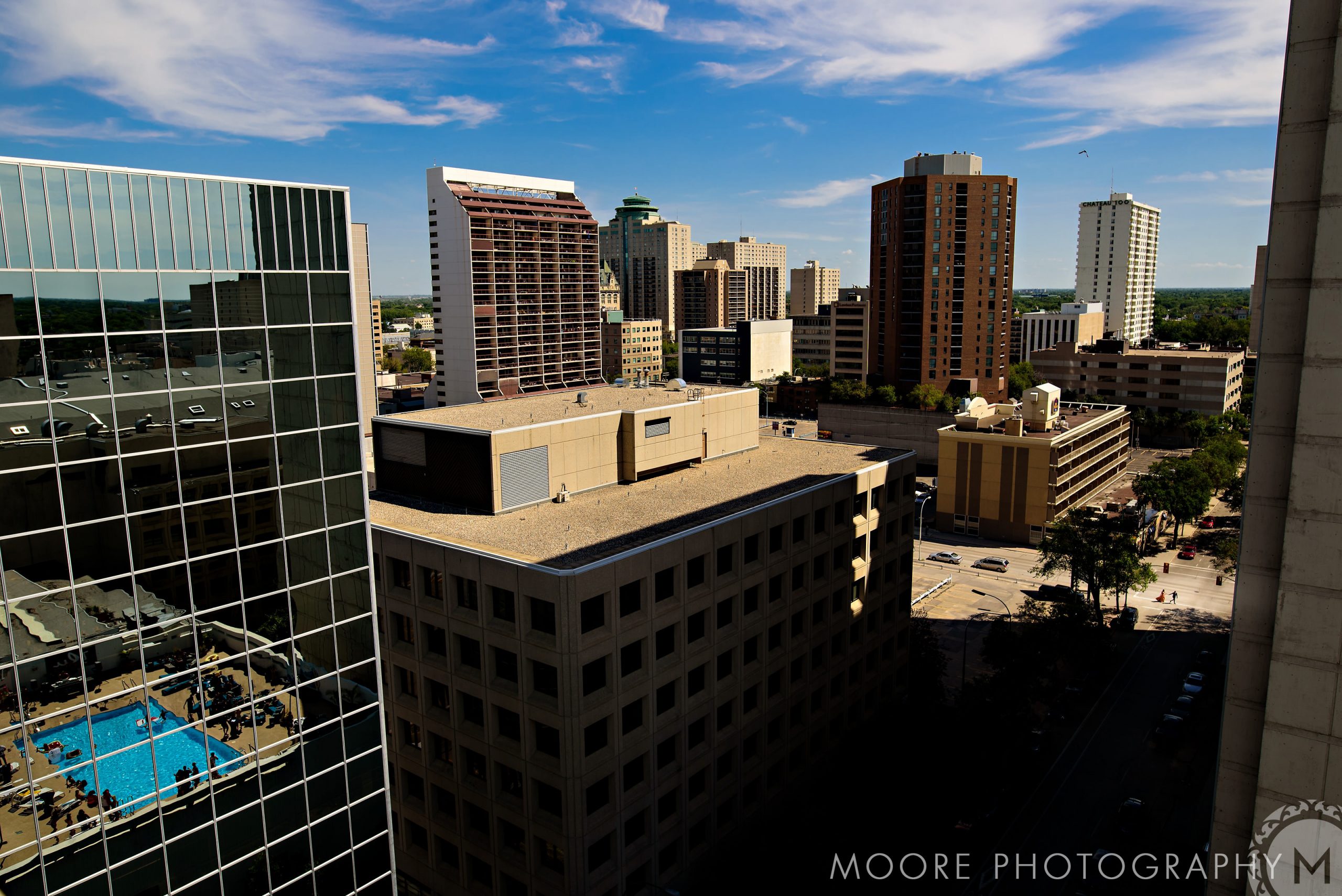 City skyline with modern buildings, a rooftop pool, and an Indian wedding at sunset.
