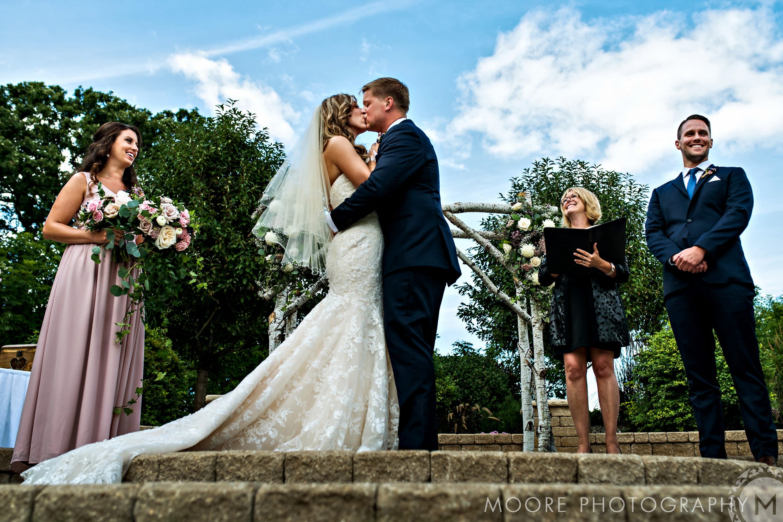 bride and groom kissing during their wedding ceremony at bridges golf course in manitoba
