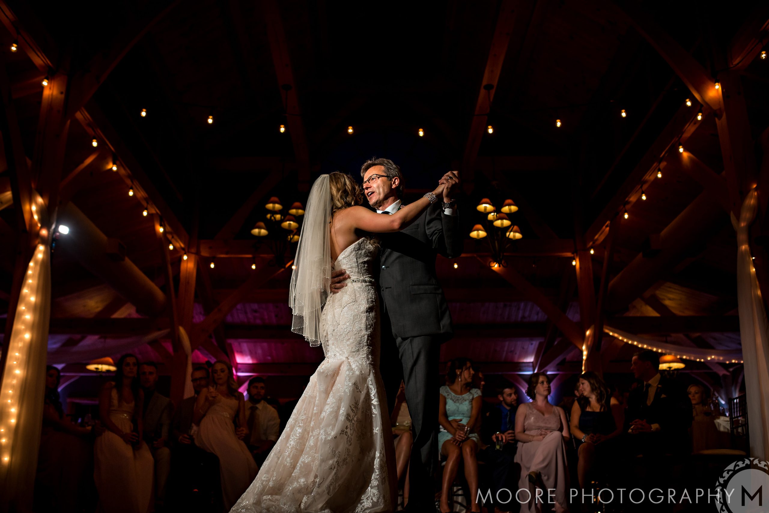 Bride and groom dance under warm lights in a charming Winnipeg wedding venue.