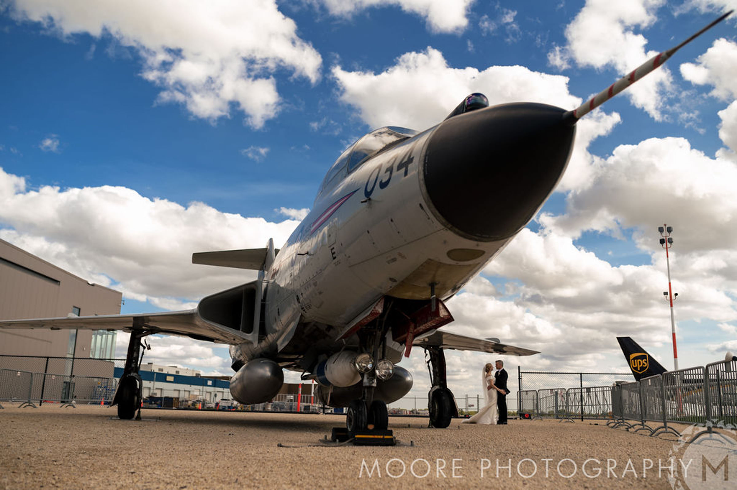 Fighter jet parked on tarmac, blue sky gracing this scene like a Winnipeg wedding venue.