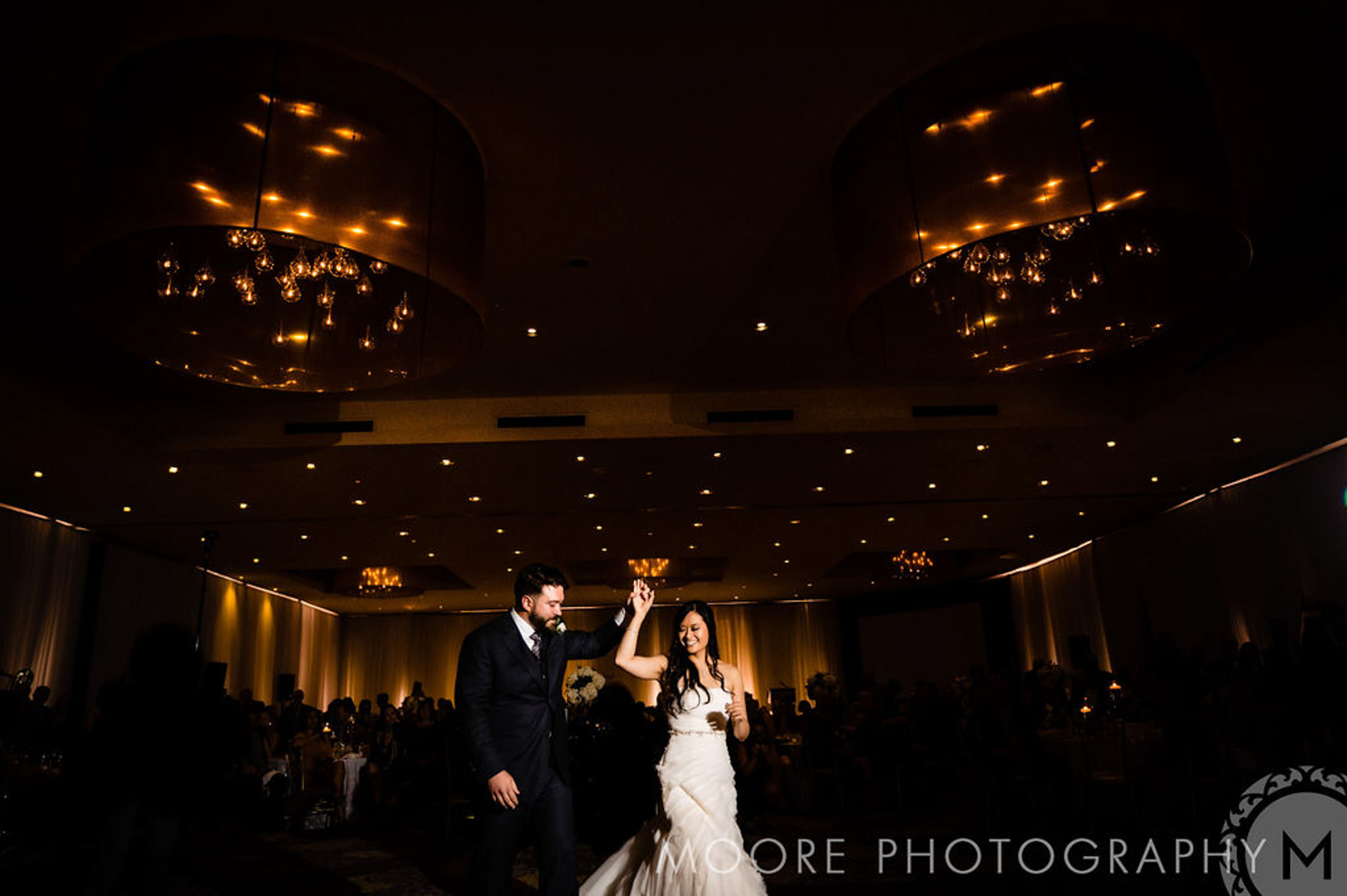 A bride and groom dancing in a dimly lit, elegant Winnipeg wedding venue.