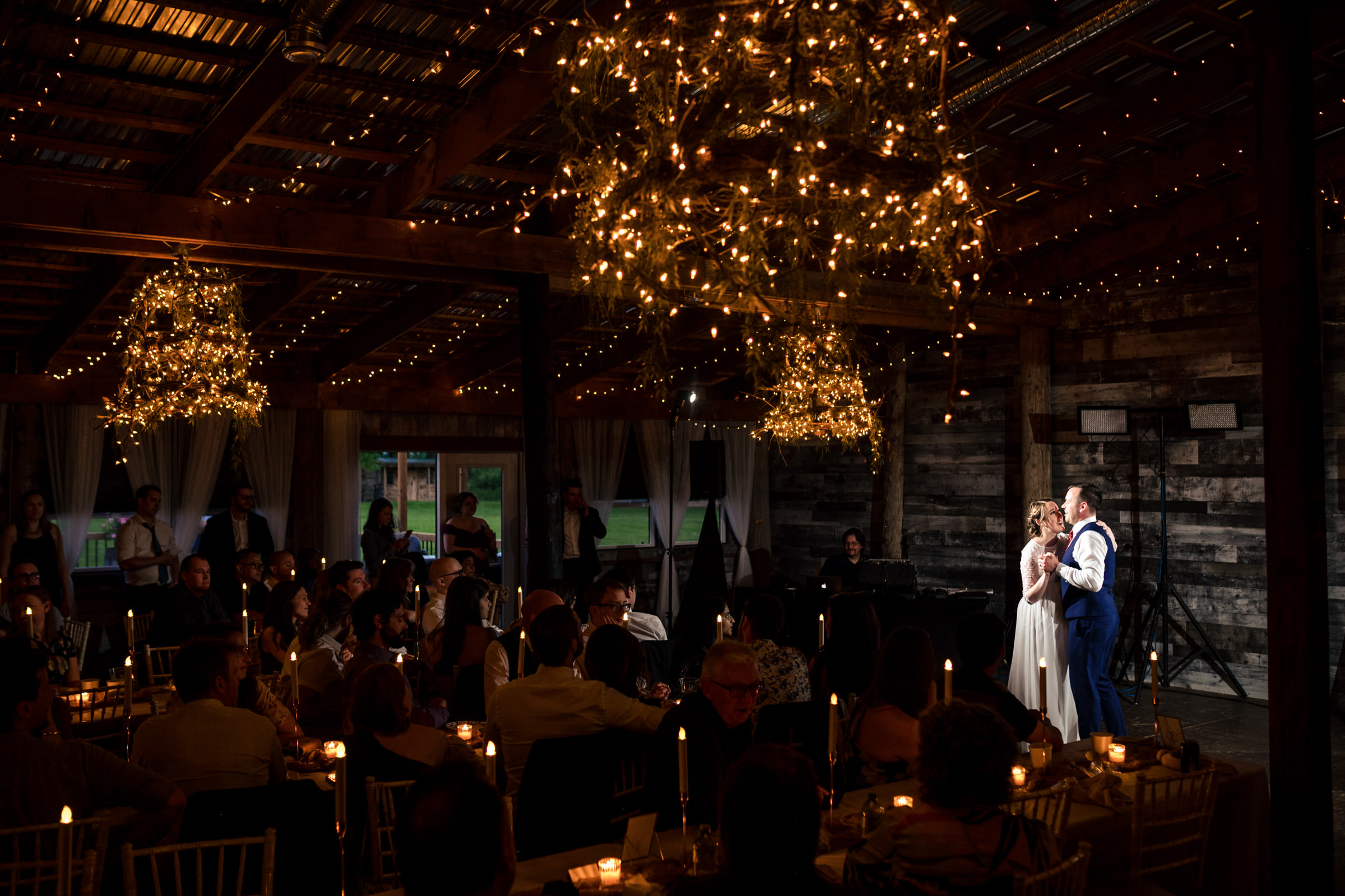 Couple dancing at a Winnipeg wedding under chandeliers in a warmly decorated venue.