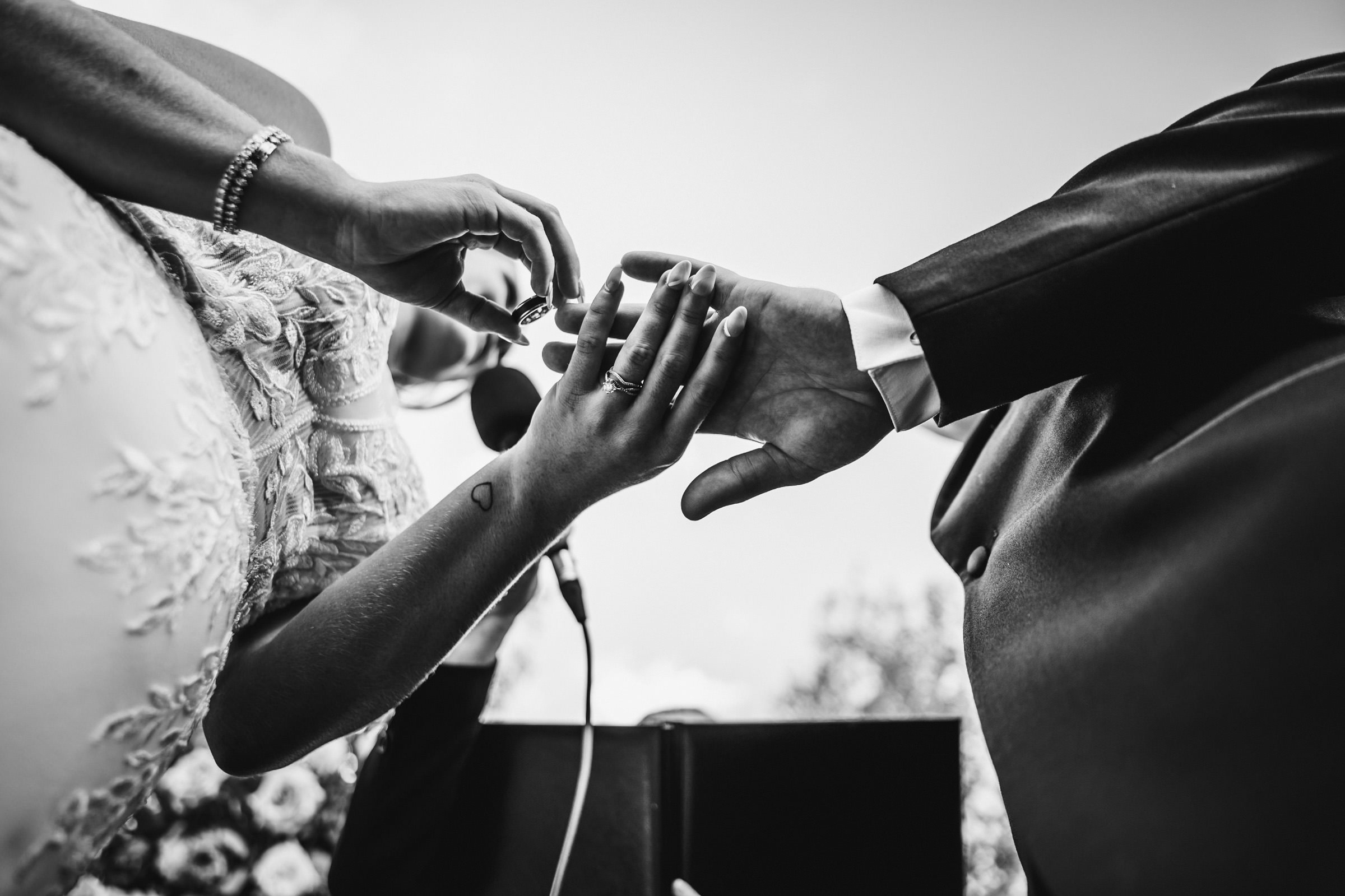Black-and-white photo of a ring exchange at a Winnipeg wedding ceremony.
