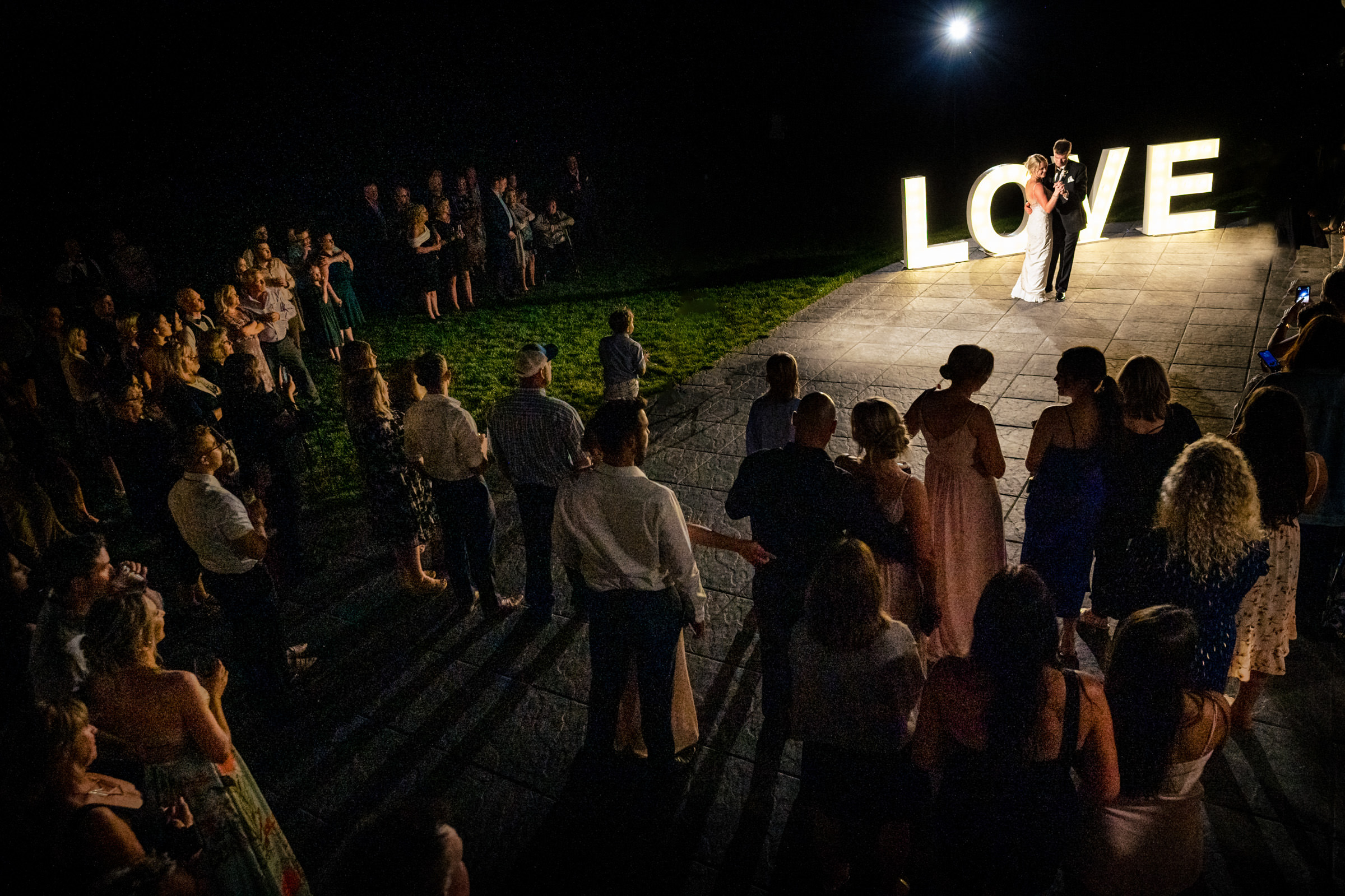 Couple dances at night under a big "LOVE" sign at popular Winnipeg wedding venue.