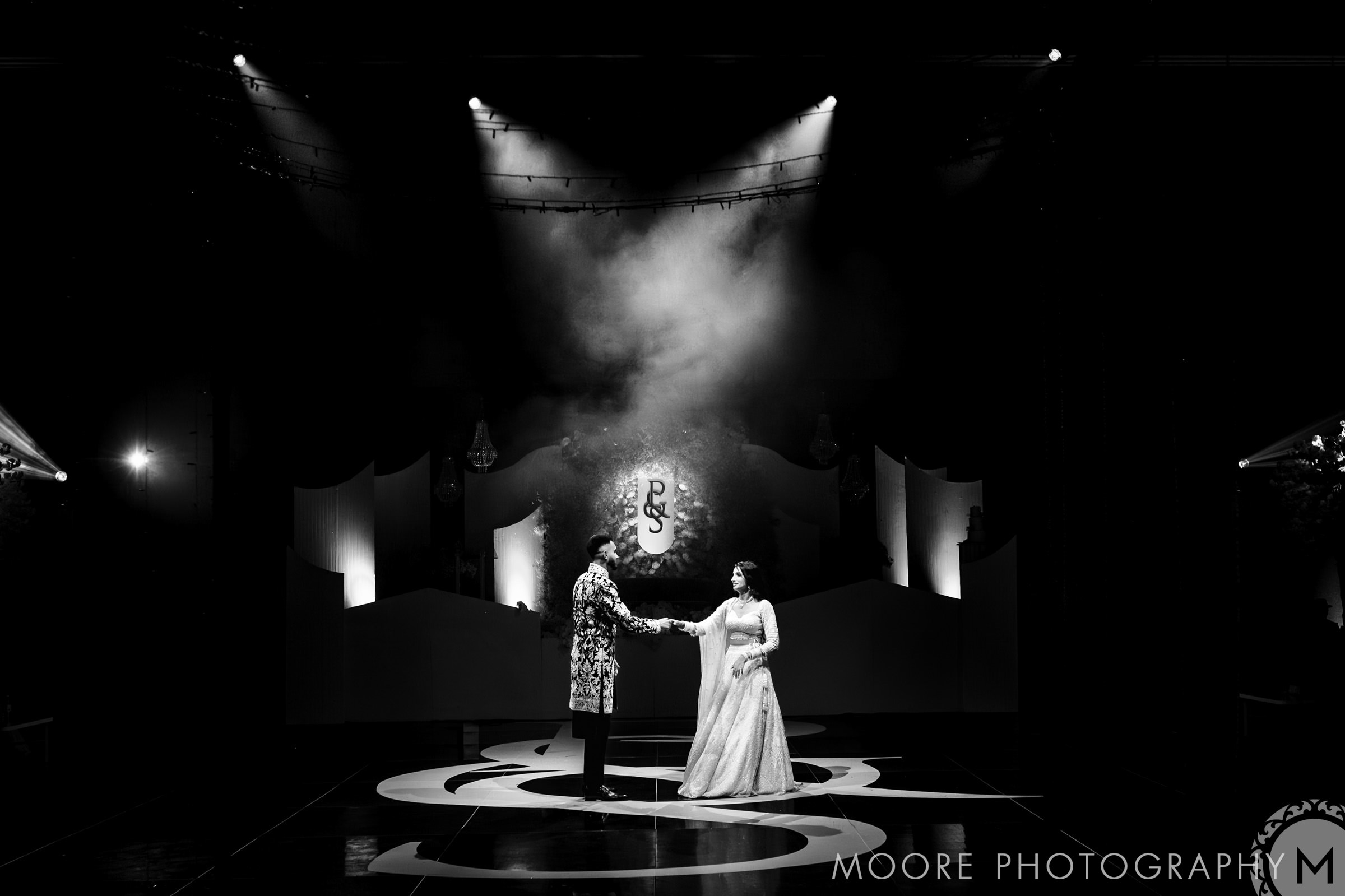 A couple dances under spotlight and smoke at a top Winnipeg wedding venue.