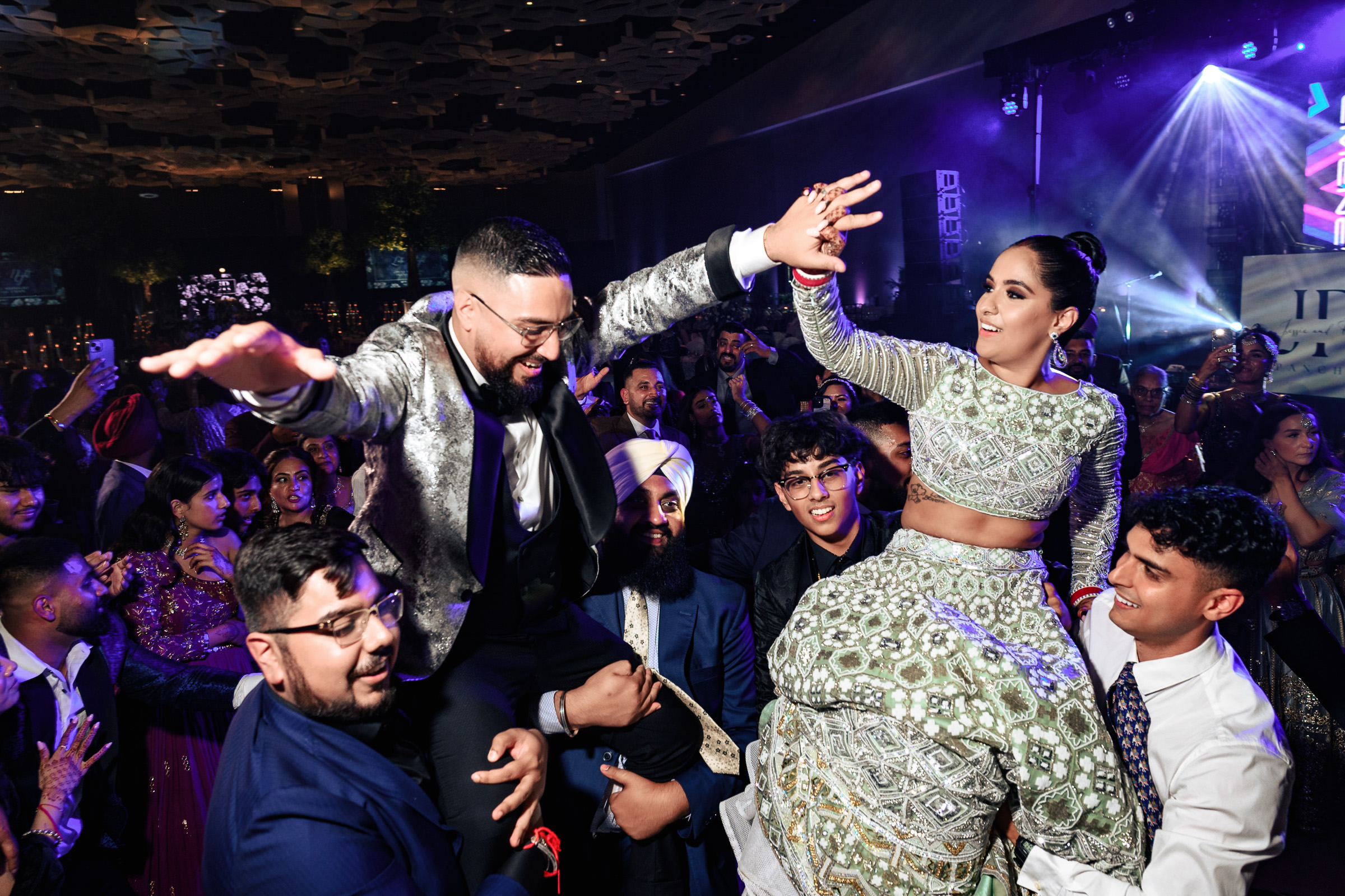 People celebrating at a vibrant Winnipeg wedding venue, dancing and cheering.
